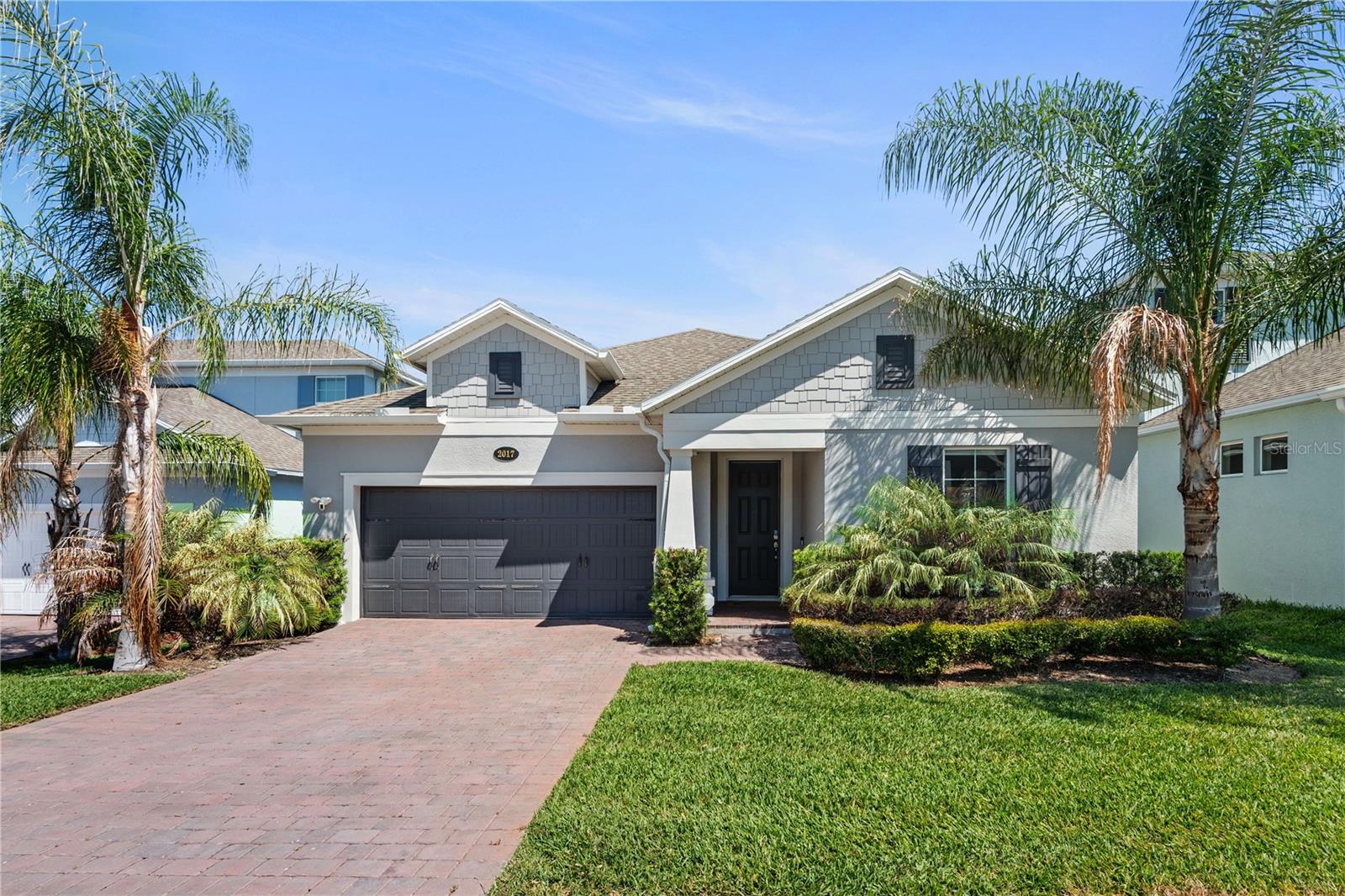 Virtually Staged. Enjoy single-level living in lakefront Hull Island in this meticulously maintained 2,852 sq ft home built in 2022, with owned rooftop solar that keeps utility costs well below the Florida norm for a home this size. Four bedrooms, four full baths, and a two-car garage, all just minutes from historic Winter Garden's shops, restaurants, and Saturday farmers market.
All four bedrooms, including the primary suite, plus the kitchen and all main living areas, are on the first floor. The only upstairs space is a private bonus suite with its own full bath, which functions equally well as a media room, flex room, or guest quarters well removed from the rest of the house.
The foyer opens into a connected great room, dining area, and kitchen, with three sliding glass doors along the back wall looking out to a covered and screened lanai. Ceramic tile runs throughout the main living areas.
The kitchen features the upgraded gas-range configuration with a Bosch refrigerator, GE stainless appliances, Silestone quartz counters, and an oversized island with seating. Finishes include 42-inch cabinets stacked to the 9'4" ceiling with crown molding. Inside: soft-close dovetail drawers, a three-tier pot and pan organizer, and a pull-out pantry.
The owned rooftop solar system was installed in 2023 and carries a 25-year limited warranty through 2048. Combined with the tankless gas water heater, it helps keep monthly utility costs exceptionally low.
The primary suite sits at the back of the first floor with a tray ceiling, dual raised-height vanities, a large walk-in shower with a built-in recessed shelf, and a walk-in closet with custom shelving that passes directly through to the laundry room.
The upstairs bonus suite measures 18'8" x 25'6" and has its own full bath. It is pre-wired as a dedicated media space, with structured Cat6 throughout, a ceiling-mounted projector outlet, and TV and data chases ready for a wall-mounted display.
Additional features include a two-car garage with a 220V/30A outlet suitable for Level 2 EV charging, a workshop, or additional appliances; a Ring doorbell, alarm system, and cameras that convey with the home; upgraded satin nickel interior door hardware with a coordinated front door handleset; upgraded light fixtures; and front gutters.
Hull Island amenities include a community pool, clubhouse, playground, and community fishing pier, with the West Orange Trail at the community's doorstep.