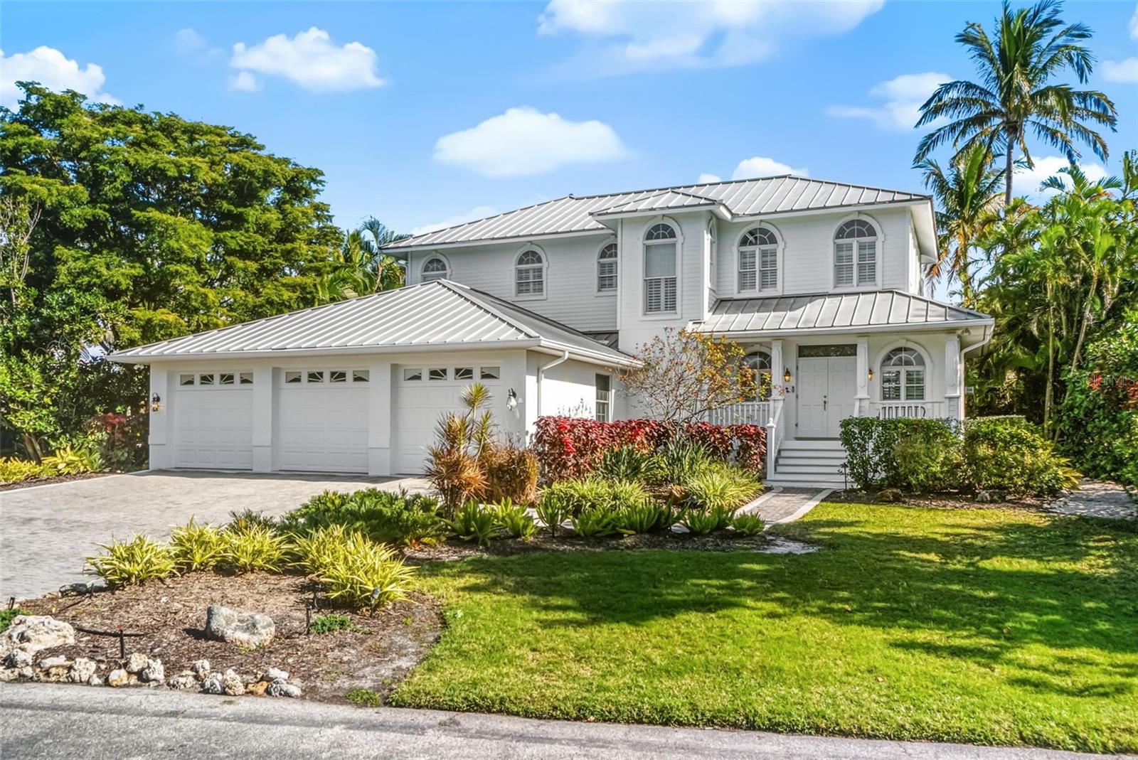 Custom Key West inspired residence in the exclusive, gated enclave of Sandhamn Place. Perfectly positioned to capture the essence of coastal living, the property boasts direct Intracoastal Waterway access, expansive water vistas, and a deeded deep-water boat dock and lift on Sarasota Bay—an extraordinary combination of luxury and lifestyle. With over 5,000 sq. ft. of living and entertaining space under roof, this timeless coastal home is ideal for gatherings both grand and intimate. A light-filled two-story foyer opens to the formal living room, framed by French doors leading onto a spacious screened Florida room—perfect for morning coffee, sunset cocktails, or restful afternoons in the breeze. The bright chef’s kitchen features a central prep island, upgraded wood cabinetry, and granite surfaces, and flows seamlessly into the dining and family living spaces. Two thoughtfully separated guest bedrooms on the first level provide flexibility and privacy:
• one en-suite with a sitting area, ideal for relaxed long-term visits or multi-use living
• the other featuring its own dedicated private entrance, perfect for guests seeking independence, an au pair, or multi-generational needs
The primary suite spans the entire second floor, creating a private haven with wood flooring, vaulted ceilings, plantation shutters, spa-inspired bath, generous walk-in closet, and a dedicated office or study. A 328 sq. ft. observation deck offers an exceptional perch for enjoying sweeping views of Sarasota Bay and serene coastal wildlife. Outdoors, the free-form open-air pool and surrounding brick terrace are embraced by lush tropical landscaping—swaying palms, mature trees including a majestic Banyan, and a natural pond that leads toward the Bay—creating a peaceful Old-Florida environment ideal for relaxation or entertaining. A three-car garage and home generator add valuable convenience and readiness. The property resides within Sandhamn Place, a private gated peninsula of just nine custom homes where residents enjoy deed restrictions, a community tennis court, marina privileges, and proximity to Longboat Key’s renowned beaches, dining, and boutique shopping. An uncommon opportunity to enjoy true waterfront living, timeless style, and exceptional privacy—this is Longboat Key living at its finest.