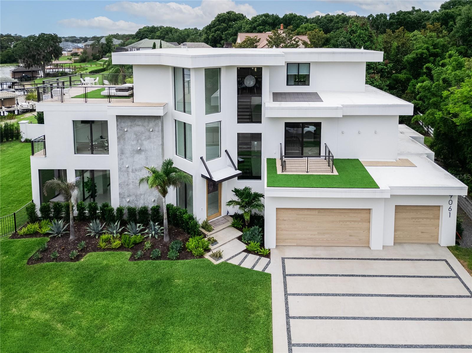 A rare architectural statement on Lake Down, this extraordinary contemporary waterfront estate redefines luxury living in the heart of Windermere.
Positioned on the prestigious Butler Chain of Lakes, this stunning residence offers 5 bedrooms, 5 full baths, 2 half baths, and a private elevator, seamlessly blending sophisticated design with effortless lakefront living. Constructed to Miami coastal specifications, the home was engineered with exceptional attention to quality, durability, and structural integrity while maintaining its striking modern aesthetic.
Floor-to-ceiling glass walls frame breathtaking water views and flood the home with natural light, while soaring ceilings and open-concept living spaces create a dramatic yet inviting atmosphere. Every detail has been thoughtfully curated, from the designer finishes and statement lighting to the seamless integration of indoor and outdoor spaces. Luxury wellness amenities, including a steam shower, further enhance the home's resort-inspired appeal.
The outdoor living experience is equally impressive, featuring a spectacular pool, expansive covered entertaining areas, and a fully equipped outdoor kitchen designed for gatherings both intimate and grand. Above it all, the rooftop terrace offers panoramic views of Lake Down and the surrounding landscape, creating the perfect setting for morning coffee, sunset cocktails, or evenings under the stars. As night falls, enjoy a truly magical experience as Disney fireworks illuminate the horizon from the comfort of your private rooftop retreat.
Whether spending the day on the Butler Chain, entertaining guests poolside, or relaxing while taking in the waterfront views, this residence delivers an unparalleled lifestyle defined by elegance, comfort, and connection to the water.
Ideally located just minutes from Restaurant Row, Downtown Orlando, the Mall at Millenia, Disney, Universal Studios, Orlando International Airport, and major thoroughfares including SR-408, this exceptional property combines the serenity of premier lakefront living with unmatched convenience.
From sunrise over Lake Down to Disney fireworks dancing across the night sky, this is a home designed to inspire, impress, and elevate everyday living.