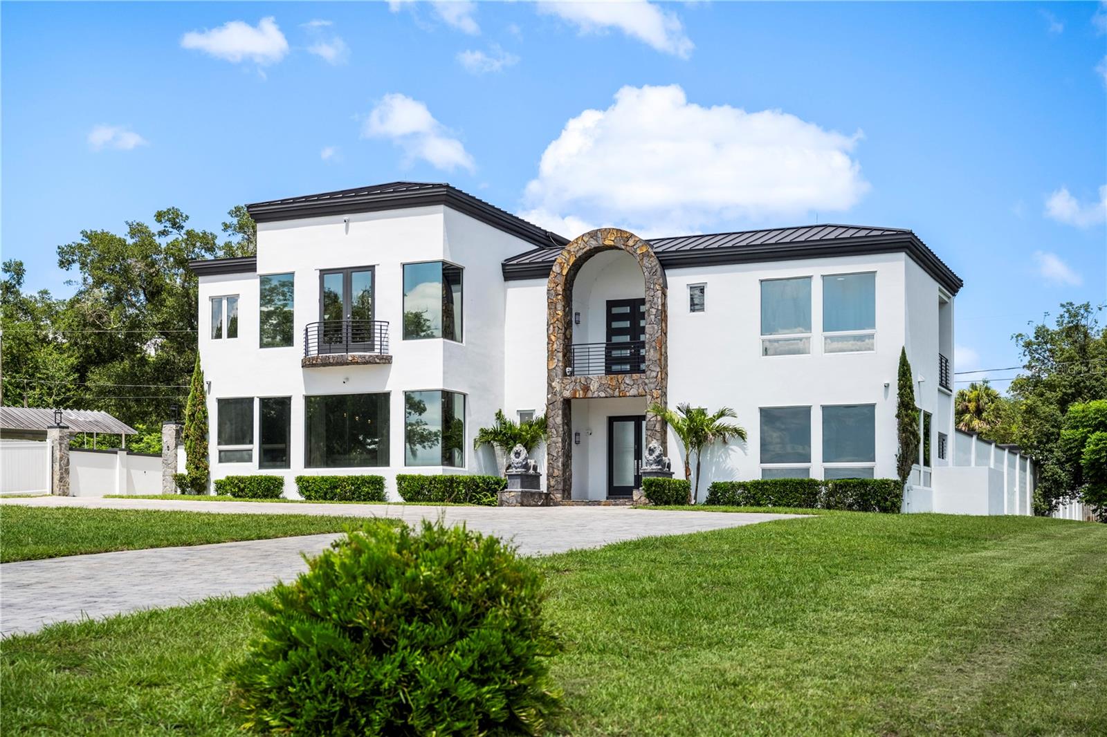 There are homes that impress, and then there are estates that become part of a family's legacy. Welcome to one of DeLand's most exceptional private lakefront estates, where contemporary architecture, cutting-edge technology, and resort-style living come together on nearly 3 acres along the shores of one of Central Florida's best-kept secrets, completely private Lake Winnemissett. With no public boat ramp, the lake remains uncrowded and crystal clear, making it one of the area's premier lakes for waterskiing, wakeboarding, and boating. Residents even enjoy a hidden sandy shoreline known locally as "South Beach."
Designed for both grand entertaining and everyday luxury, this custom estate showcases soaring ceilings, walls of glass, expansive lake views, and a seamless indoor-outdoor floor plan centered around a resort-style pool and spa. Multiple primary suites, spacious guest accommodations, and thoughtfully designed living spaces provide exceptional comfort and privacy.
Technology enthusiasts will appreciate the updated Crestron Smart Home system with in-wall iPads in each room, whole-house audio, integrated lighting and climate controls, updated theater equipment, and modern smart-home automation throughout. Significant recent improvements include four new HVAC systems, updated pool automation, a premium standing-seam metal roof, and a whole-house generator powered by a 1,000-gallon underground propane tank capable of operating the home for approximately one week during power outages.
Outside, enjoy nearly three acres of beautifully maintained grounds with direct lake frontage, a permitted dock and boathouse, and a boat lift designed for a 24-foot wake boat, making lake life effortless. Automotive enthusiasts, collectors, and hobbyists will love the detached 1,200 soft climate-controlled showroom/garage complete with vehicle lift, offering endless possibilities for a premium collection, workshop, or recreational space.
This is a rare opportunity to own one of Central Florida's finest private waterfront estates—where luxury, technology, privacy, and recreation come together in an extraordinary setting.