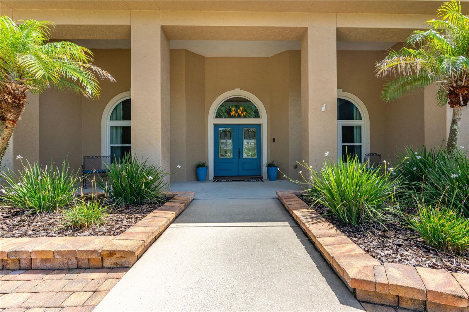 RARELY AVAILABLE, THIS SINGLE-STORY 5-BEDROOM, 4-BATH EXECUTIVE HOME OFFERS OVER 4,296 SQUARE FEET OF LIVING SPACE ON AN OVERSIZED 1.5-LOT LAKEFRONT HOMESITE, COMPLETE WITH A SCREENED SALTWATER POOL, TWO PRIMARY SUITES, AND A RARE AIR-CONDITIONED 5-CAR GARAGE.

SITUATED AT THE END OF A QUIET CUL-DE-SAC, THIS EXCEPTIONAL RESIDENCE OFFERS THE PRIVACY, SPACE, AND FLEXIBILITY TODAY'S LUXURY BUYERS ARE LOOKING FOR. DESIGNED FOR BOTH EVERYDAY COMFORT AND EFFORTLESS ENTERTAINING, THE HOME FEATURES SOARING CEILINGS, EXPANSIVE LIVING AREAS, AND A THOUGHTFULLY DESIGNED SPLIT FLOOR PLAN THAT INCLUDES TWO PRIVATE PRIMARY SUITES—PERFECT FOR MULTI-GENERATIONAL LIVING, EXTENDED FAMILY, OR LONG-TERM GUESTS.
AT THE CENTER OF THE HOME, THE CUSTOM CHEF'S KITCHEN IS DESIGNED TO IMPRESS WITH LEATHERED QUARTZITE COUNTERTOPS, CUSTOM CABINETRY, AN OVERSIZED ISLAND WITH INFRARED COOKTOP, ABUNDANT STORAGE, AND A SUNNY BREAKFAST AREA OVERLOOKING THE POOL AND LAKE. THE ADJACENT FAMILY ROOM WITH FIREPLACE CREATES A WARM AND INVITING GATHERING SPACE FOR FAMILY AND FRIENDS.

THE PRIMARY SUITE SERVES AS A PRIVATE RETREAT WITH DIRECT POOL ACCESS, DUAL WALK-IN CLOSETS WITH CUSTOM BUILT-IN ORGANIZATION, AND A BEAUTIFULLY UPDATED SPA-STYLE BATH FEATURING DUAL VANITIES, A SOAKING TUB, AND AN OVERSIZED WALK-IN SHOWER.

STEP OUTSIDE TO YOUR OWN PRIVATE FLORIDA RESORT. THE SCREENED LANAI OVERLOOKS A SOLAR-HEATED SALTWATER POOL WITH A DECORATIVE FOUNTAIN, WHILE THE POOL ENCLOSURE WAS REPLACED IN 2024. THE COVERED OUTDOOR LIVING AREA FEATURES CUSTOM CABINETRY, A SINK, REFRIGERATOR, AND AMPLE SPACE FOR YEAR-ROUND ENTERTAINING. MATURE TROPICAL LANDSCAPING, PEACEFUL LAKE VIEWS, IRRIGATION, BEAUTIFUL LANDSCAPE UPLIGHTING, ACCENT LIGHTING, AND A FENCED BACKYARD COMPLETE THIS PRIVATE OASIS.

CAR ENTHUSIASTS, HOBBYISTS, AND COLLECTORS WILL APPRECIATE THE RARE AIR-CONDITIONED 5-CAR GARAGE FEATURING CUSTOM CABINETRY, ATTIC STORAGE, AND GENERATOR WIRING. ADDITIONAL UPGRADES INCLUDE A 2018 ROOF, A/C APPROXIMATELY 7 YEARS OLD, NEW FRONT WINDOWS AND ENTRY DOOR (2022), DUAL HVAC SYSTEMS, WHOLE-HOUSE WATER TREATMENT, SOLAR HOT WATER, CENTRAL VACUUM, HURRICANE SHUTTERS, LED LIGHTING, INDOOR AND OUTDOOR SPEAKER SYSTEMS, UNDERGROUND DRAINAGE, AND MUCH MORE.

LOCATED WITHIN ONE OF PORT ORANGE'S PREMIER GATED COMMUNITIES AND JUST MINUTES FROM TOP-RATED SCHOOLS, SHOPPING, DINING, GOLF, MEDICAL FACILITIES, AND THE AREA'S BEAUTIFUL BEACHES, THIS PROPERTY OFFERS A COMBINATION OF SIZE, PRIVACY, AND AMENITIES RARELY FOUND IN TODAY'S MARKET.

SINGLE-STORY. LAKEFRONT. 5-CAR GARAGE. TWO PRIMARY SUITES. RESORT-STYLE OUTDOOR LIVING.
HOMES OF THIS CALIBER RARELY BECOME AVAILABLE IN THE PORT ORANGE AND NEW SMYRNA BEACH AREAS. SCHEDULE YOUR PRIVATE SHOWING TODAY AND EXPERIENCE EVERYTHING THIS EXTRAORDINARY EXECUTIVE HOME HAS TO OFFER.

ALL MEASUREMENTS AND INFORMATION DEEMED TO BE ACCURATE BUT CANNOT BE GUARANTEED. BUYERS AND REALTORS ARE ENCOURAGED TO VERIFY. SEE REALTOR REMARKS FOR EXTRA ITEMS AND INFORMATION.