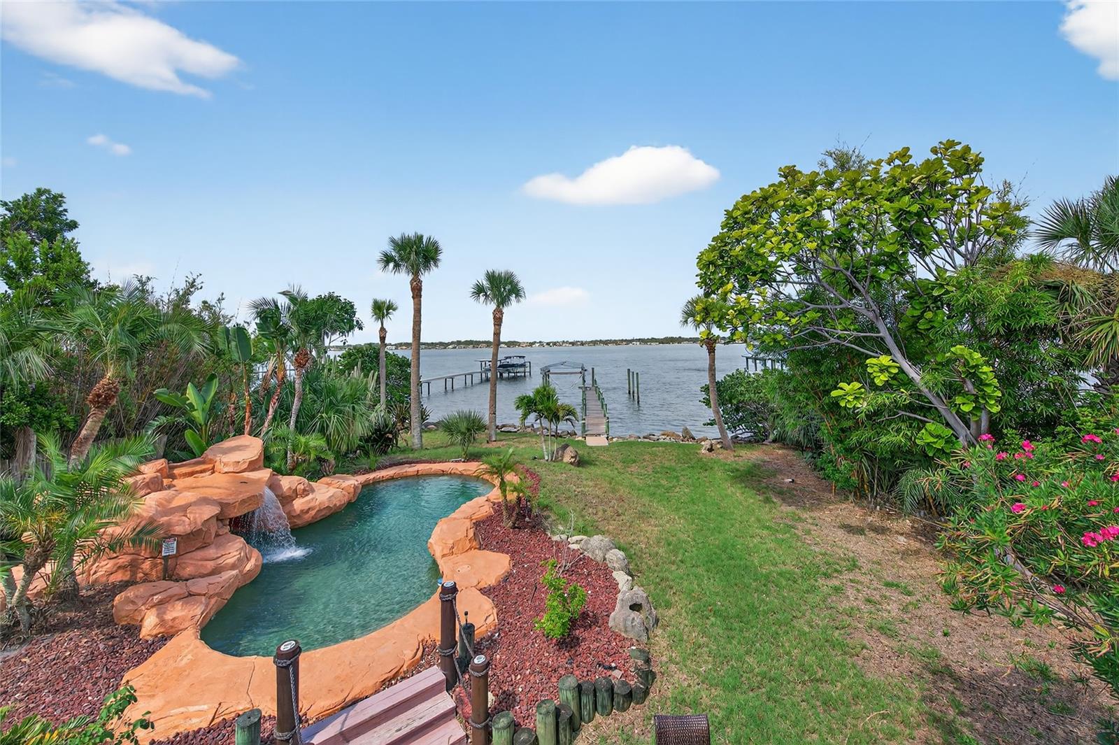 Waterfront living on the Halifax River with sunsets, dolphins, and your own dock and boatlift as the backdrop.

This 5-bedroom, 5-bath home offers plenty of space with a great room featuring vaulted ceilings, a statement staircase, and iron balcony details. You’ll also find a dedicated office, game room, and multiple living areas.

The kitchen is built for function and entertaining, with a layout that works for more than one cook. Upstairs, the primary suite includes a private riverfront balcony with direct access to the backyard. A separate downstairs suite is ideal for guests, in-laws, or teens.

Out back: freeform pool, tropical landscaping, waterfall with a grotto, and a brick paver patio with wet bar—all overlooking the river and your own private dock.

If you want a home that actually feels like Florida, this is it, and just 3 minutes from beach access.