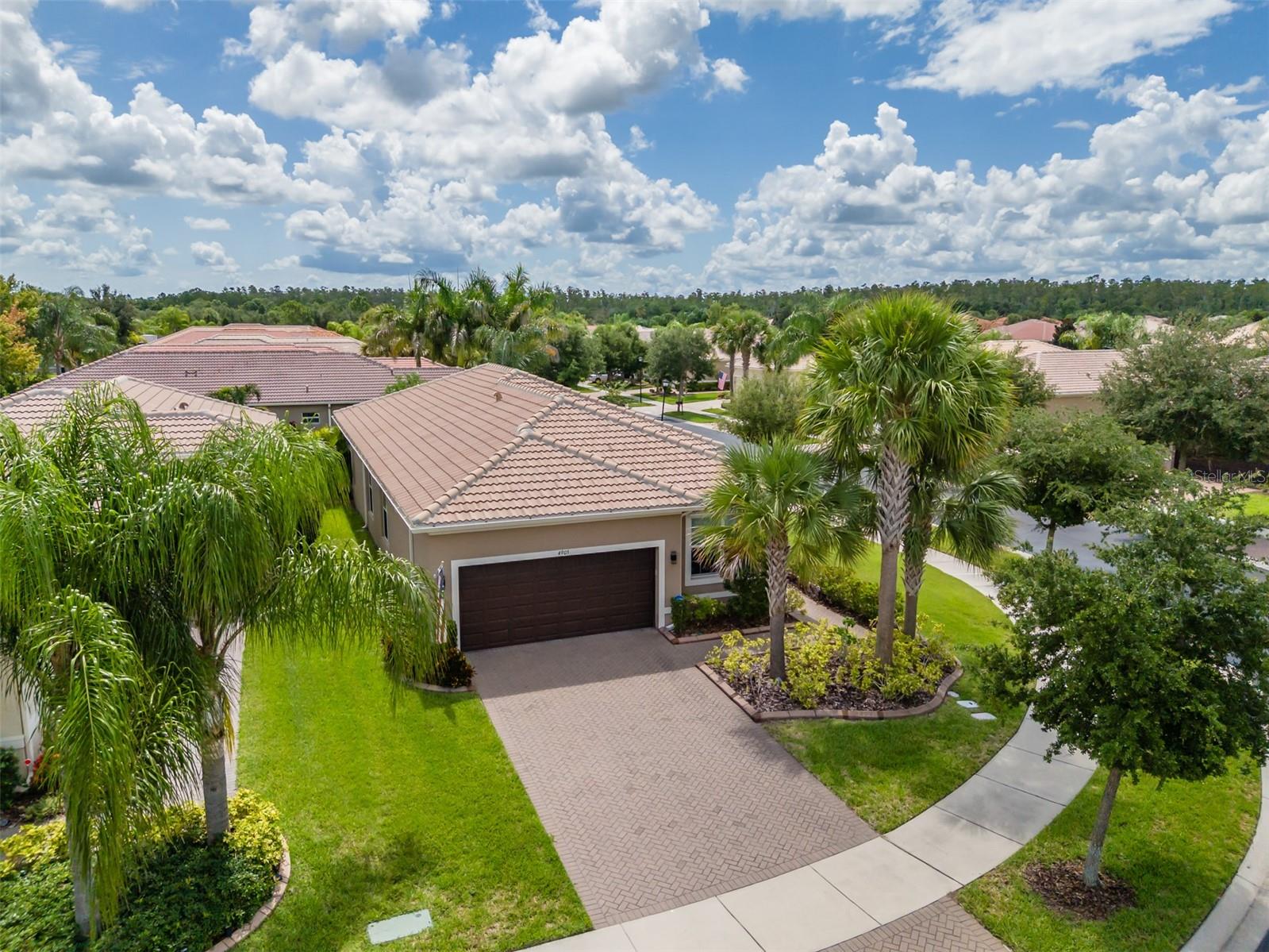 **ASSUMABLE 2.25% VA LOAN-- Available to everyone**. Experience Resort-Style Living in Valencia Lakes! Welcome to this impeccably maintained 2018 GL Homes Positano model, offering 2,001 square feet of thoughtfully designed living space in Valencia Lakes, Tampa Bay’s premier 55+ Active Adult Community. An inviting 9’x11’ foyer with a tray ceiling welcomes you into this natural light-filled home, where elegant 18”x18” porcelain tile flooring flows throughout the common living areas. The front entry is enhanced with a Phantom retractable screen door, allowing you to enjoy Florida’s beautiful cross breezes. Designed with entertaining in mind, the open-concept kitchen is the heart of the home and features quartz countertops, stylish gray cabinetry, a stunning mosaic glass-tile backsplash, a single-basin sink with a reverse osmosis drinking water faucet, Whirlpool refrigerator, GE Stainless Steel range, microwave (2026), and dishwasher (2026), pantry with pull-out sliders, and abundant workspace for the home’s chef. The adjoining dinette offers casual dining beneath a lighted ceiling fan. The dining room is beautifully illuminated by a large window and elegant chandelier and comfortably accommodates seating for eight, making special gatherings and dinner parties effortless. The spacious great room features 8 recessed lights, a lighted ceiling fan, and it opens through 12’ sliders to the lanai/screen room. Enjoy outdoor living in the 20’x17’ lanai/screen-room which features a Florida Glass wall that enhances privacy and comfort, a durable hardtop roof, and a lighted ceiling fan; this is a perfect space for relaxing with your morning coffee or entertaining guests in the evening. Retreat to the luxurious primary suite featuring two open-access walk-in closets, a large 9’ window, and a spa-inspired en-suite bath with separate quartz-topped vanities and oversized walk-in shower complete with a built-in bench. A versatile den with double doors, a large window, and a lighted ceiling fan offers the perfect space for a home office, hobby room, or optional third bedroom. The split-bedroom floor plan provides privacy for guests. Bedroom two, with a Murphy bed, is tucked away from the primary suite and features plush carpeting, a ceiling fan, and convenient access to the second bath with a quartz banjo-style vanity and framed tub/shower combination. The well-appointed laundry room includes a utility sink and GE top-load washer and dryer (2026). Additional upgrades include custom top-down/bottom-up window shades throughout the home, a Carrier Infinity HVAC (2023), Rheem water heater (2023), Culligan water softener, insulated garage door, quiet belt-drive garage door opener, and a high-ceiling in the garage offering excellent storage potential. Beyond your front door, enjoy the award-winning lifestyle of Valencia Lakes. Residents enjoy a magnificent clubhouse, resort-style pools, fitness center, tennis & pickleball courts, bocce, softball, scenic walking and biking trails, community garden, dog park, on-site restaurant, and a full calendar of clubs, entertainment, social events, and activities. Valencia Lakes offers the perfect blend of luxury, convenience, and active living. This exceptional Positano model has been lovingly maintained and is truly move-in ready. Don’t miss your opportunity to enjoy the very best of Florida’s resort-style lifestyle!