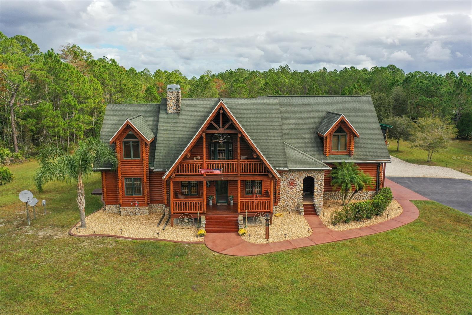 Here’s a rare opportunity to own a 10 acre estate with private pond, dock, screened in pool/spa, RV building with 50 amp hookup, & a stunning 3444 sq ft log cabin custom home in a gated equestrian community.  This home is immaculately well maintained and there are so many amenities that you will have to see them first hand to appreciate.  The living room, kitchen, and formal dining room are all open with views of a stunning wood burning fireplace, 700 sq ft four-seasons screened room with full bar that walks out to a salt water pool and spa.  The spacious master bedroom and bath are located on the main floor for privacy and there are 3 spacious bedrooms and additional loft upstairs.  Other amenities include: 3 car garage, separate 600 sq ft mother-in-law area with private entrance, 2 AC units (3 years old), new sealed driveway, well with new pump (2 years old), Double oven, new stainless steel large farm sink, refrigerator, dishwasher (2 years old), new custom built center kitchen island with custom matching bar stools (optional),  gorgeous original hardwood flooring, new laminate flooring upstairs, beautiful ceiling fans, stunning vaulted ceilings, large laundry room with mop sink, ADT security, new RV building (15 ft high clearance, 18 x 50 size), upstairs bonus loft, plenty of closets & storage, wooden playground swing set, 3 acres of underground pet fencing, outdoor shooting range with berm, & outdoor walkout balconies & porches with stunning views.  Low $550.00 annual HOA’s.  Only 18 miles to Sanford/Orlando airport and 19 miles to one of Florida’s best beach towns with fine dining and shopping.  This home will not last long and is one of the most stunning homes listed in Volusia County.  


All information intended to be accurate but not guaranteed.
