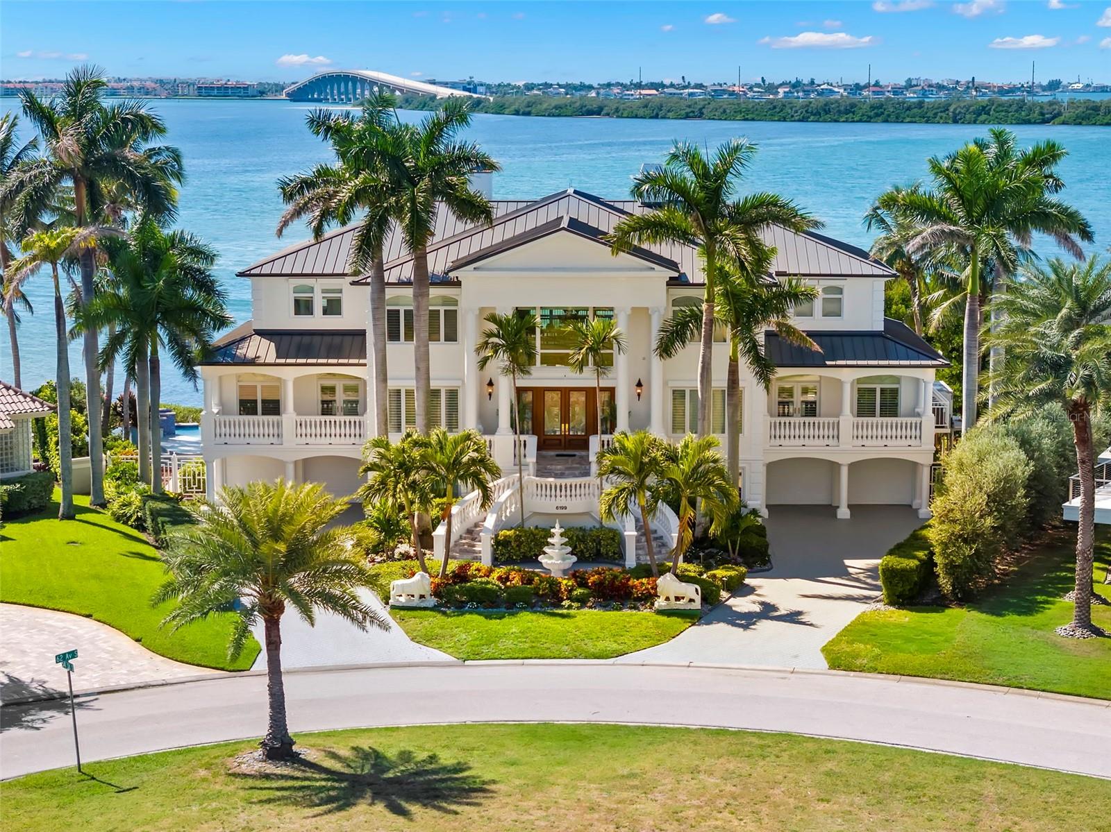 Under contract-accepting backup offers. There are homes you live in and homes that elevate the way you live. This breathtaking waterfront estate does just that! Welcome to an extraordinary waterfront estate in the prestigious, guard-gated community of Bayway Isles. As you step through the stunning leaded glass double doors, your eyes are immediately drawn to the breathtaking open-water views. Perfectly positioned on an expansive point lot with 135 feet of waterfront, this residence captures spectacular sunsets and embodies the best of Florida luxury living. Spanning 7,114 square feet of living space with an impressive 3800 SF of fabulous balconies to enjoy outdoor living, this 5-bedroom, 5.5-bath home was designed with timeless elegance, impeccable craftsmanship, and effortless indoor-outdoor flow.  A private elevator servicing all levels immediately sets this residence apart, offering both convenience and luxury.  The home has recently undergone substantial upgrades, including a brand new charcoal-colored metal roof with lifetime warranty, freshly painted exterior, and a fully updated kitchen with modern white cabinetry and top-of-the-line stainless steel appliances.   The main living level features stunning marble flooring, a spacious great room with amazing water views, a custom wet bar, theater screen,a formal waterfront dining room and a convenient powder bath. Also on this level is a generous guest suite with en-suite bath, a walk-in pantry, and a fabulous office with built-ins. The top floor is dedicated to four bedroom suites arranged in a split plan, providing the generous primary suite its own private wing. The primary retreat showcases expansive water views, plantation shutters, a spacious custom walk-in closet with center island, and a newly remodeled bath with dual vanities, jacuzzi tub, walk-in shower, and abundant cabinetry. The refinished hardwood floors extend throughout the upper level, where all bedrooms are generously sized and filled with natural light.  Exceptional build quality of this all block constructed residence includes 6" poured concrete floors, hurricane shutters, a whole-house generator, and the split four-car garage features epoxy flooring. Also downstairs you have a private gym The resort-style backyard has been thoughtfully enhanced with a beautifully refurbished infinity-edge pool and deck, surrounded by lush tropical landscaping, and programmable lighting for year-round enjoyment. A brand-new dock with 16,000 lb boat lift, and new generator further elevate the home’s appeal. (Lastly there is a  low transferrable flood insurance (under $2,000 annually) and 1600 SF of additional bonus/storage area.  Ideally located just 10 minutes from vibrant Downtown St. Petersburg and 30 minutes to Tampa, with no bridges to open water, this exceptional estate offers a truly rare combination of luxury, lifestyle, and location.