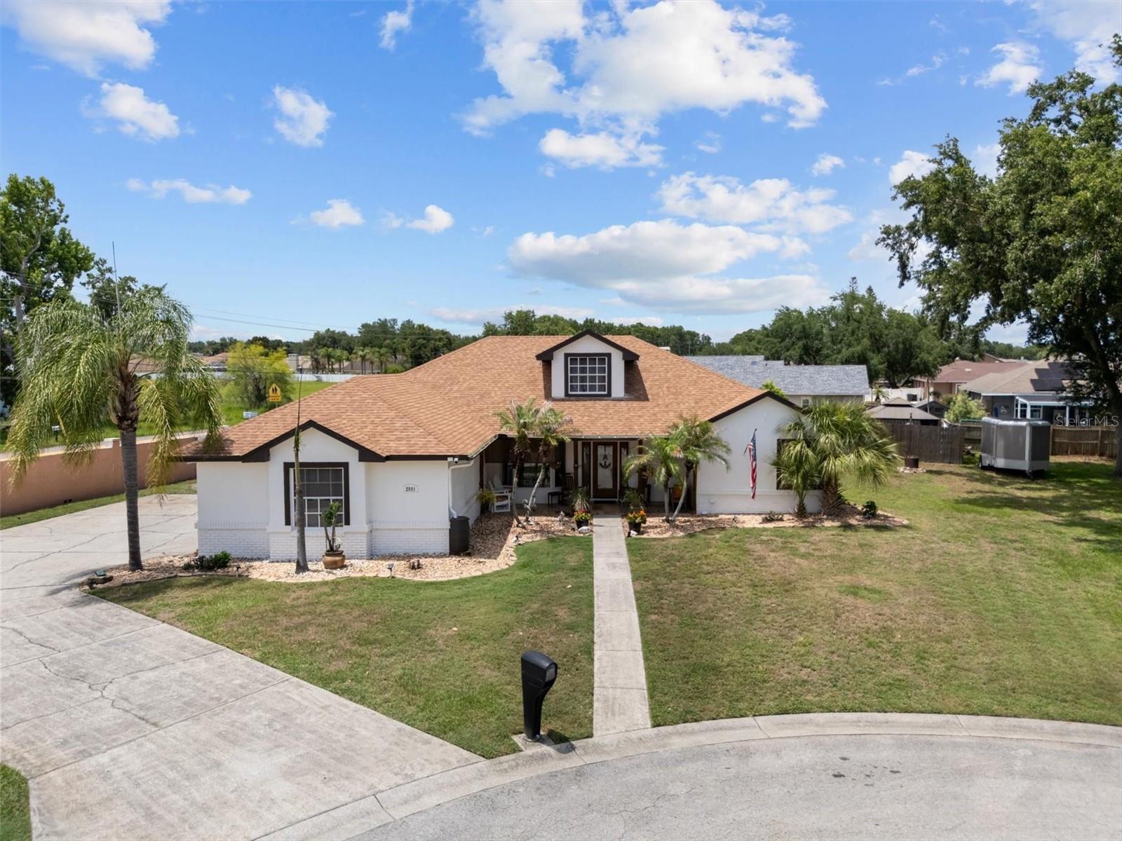 Welcome to this exceptional single-family home in desirable South Lakeland, conveniently located near the Polk Parkway, shopping, dining, and just a short distance from Valley View Elementary. Designed with a spacious split-floor plan ideal for multi-generational living, this single-story residence offers five bedrooms and three full bathrooms, including a luxurious primary suite featuring two walk-in closets and a newly remodeled en-suite bath with double vanities and an impressive 5x9 walk-in shower with multiple shower heads. Two additional bedrooms and a full bath are privately situated along one hallway, while two more bedrooms and a third full bath are located off the second living area. Inside, you'll find two separate living rooms, two dining spaces, an indoor laundry room, and a stunning 20x21 bonus room filled with natural light from expansive windows and direct access to the pool area. The outdoor living space is equally impressive, showcasing a covered saltwater pool with heating, a sun shelf with fountains and umbrella holder, depths ranging from 3 to 6 feet, and abundant covered seating for entertaining. The large backyard also includes a covered outdoor cooking area, fire pit, storage shed, wood privacy fence, and ample room for recreational vehicles. Additional highlights include a wood-burning fireplace, covered front porch, extra-long driveway, three-car garage, cul-de-sac location, and a generous lot that offers both privacy and space to enjoy Florida living at its finest **upgrades** Roof(2022), Pool(2023), Exterior paint(2025), Primary bathroom remodel(2026).