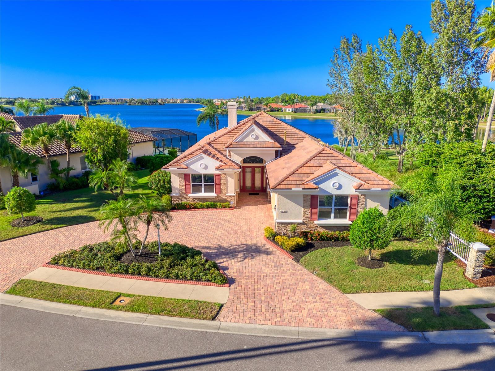 EXPERIENCE THE ULTIMATE LUXURY OF LAKEFRONT LIVING!! BACK ON THE MARKET!! **NEW TILE ROOF JUST INSTALLED!!** This is a UNIQUE OPPORTUNITY to live in an EXQUISITE HOME in a PREMIER LOCATION w/ TRANQUIL WATER VIEWS! Take pleasure in the exceptional & timeless features of this Elegant & Classic residence. Custom Built by Arthur Rutenberg, this home is ideally located on the banks of majestic Lake Uihlein, a private 153-acre lake fed by natural springs. An adjacent Waterside Park offers a buffer of Natural Beauty. Enter the property via a CIRCULAR DRIVEWAY leading to a spacious Side-Entry 2-CAR GARAGE. Double Entry Doors welcome you to a very impressive Residence, featuring an ideal Spacious & Open Floor Plan w/ Tall 12’ Ceilings, 8’ Doors, Crown Molding & Large Windows to allow daily doses of natural light. Abundant space for living & entertaining with 3 BEDROOMS + DEN & 2 1/2 BATHS in 2,546 sf. Enjoy amazing WATER VIEWS from several rooms. ~The Expansive Gourmet Kitchen is equipped w/ stainless steel appliances, pull-out shelving, abundant counter space & ample storage - while a large window in the Kitchen Dining Area displays panoramic views of the Lake. ~The sunlit & grand Family Room is stylishly customized w/ Built-in Shelves & a Gas Fireplace. The Spacious Primary Suite features a WALL of SLIDING DOORS, leading to an extended Lanai on the Lake. Experience the convenience of 2 Walk-In Closets & an En-Suite Bathroom with a Jetted Tub, Walk-In Shower, Water Closet and Double Sinks. ~Two additional private Bedrooms share a Full Bathroom – ideal for guests or family. ~A spacious 4th Bedroom or Office/Den provides flexible work or bonus space. ~An elegant formal Dining Room offers a private space for entertaining & family dining. Take advantage of the unique Indoor/Outdoor Florida Lifestyle as you Entertain, Dine or Relax on the Extended Lanai - w/ Panoramic Screens to maximize LAKE VIEWS, an Outdoor Kitchen w/ a Gas Barbeque & Outdoor Shower. Swim, Refresh & Rejuvenate in the heated Pool & Spa. The Lanai is a tranquil morning spot to watch the water birds & sip coffee. In the evening, you will have a front row seat to experience BREATHTAKING SUNSETS over the Lake. The large 2-Car Garage w/ Workshop & Epoxy Floor features extended height, extra width & abundant storage. Additionally this extraordinary home features a New A/C 2024 & Gas Water Heater 2022 & Central Vacuum System. Edgewater Village is a Premier, Gated community centrally-located in Lakewood Ranch & featuring both Privacy & Convenience for residents. Imagine living among lush, mature landscaping & tranquil water views – while also located within walking or biking distance to Lakewood Ranch Main Street, next to the Lakewood Ranch Country Club & across the street from Sarasota Polo Club! Edgewater Village residents can enjoy walks around the Lake, relaxing at the Gazebo, Fishing from a Private Pier & access to Small Boat Storage. Access everything in minutes- I-75 for quick travel, UTC Center for shopping, fine restaurants & attractions, Lakewood Ranch trails, parks & events, Lakewood Ranch Medical Center, Waterside farmers markets, downtown Sarasota dining & culture, St. Armand’s Circle, Award-Winning Gulf Beaches & Sarasota Airport. Discover why Lakewood Ranch is the #1 selling planned community in the US!! This is your Florida Paradise - in idyllic Edgewater Village – Lakewood Ranch.