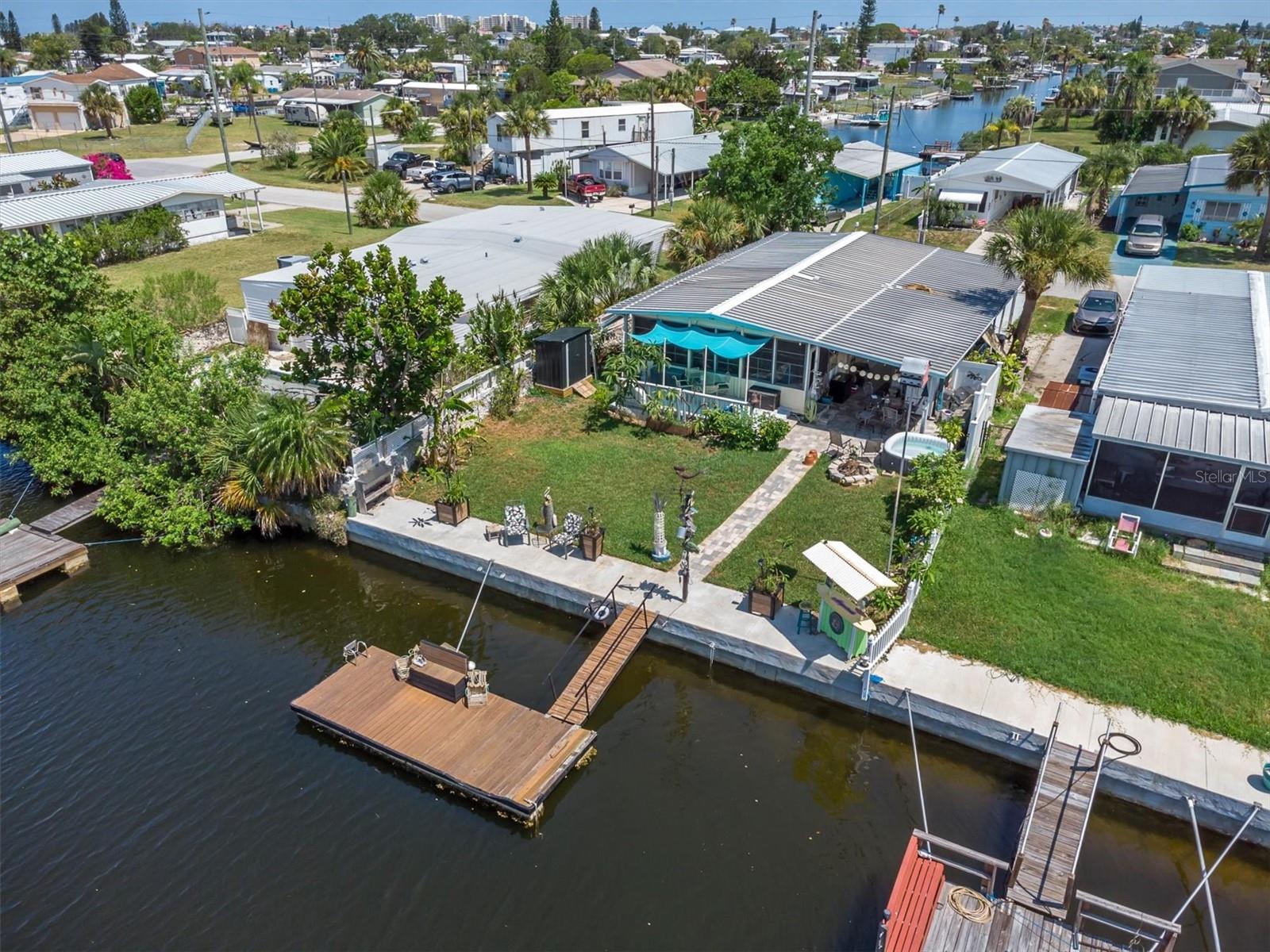 Gorgeous, Canal home that has EVERYTHING you need! MOVE IN Ready! This almost, fully furnished two-bedroom, 2 bathroom home is on a VERY deep canal and has direct access to the Gulf within 5 minutes, with no bridges. You will see plenty of dolphins & marine life on this canal!  It is a 5,000 sq ft, fenced in lot with 50 ft of water frontage & a seawall that has recently been reinforced. The home is "packed" inside & out with features & is beautifully decorated. On the exterior "water side", there is a large floating dock with running water and electricity, a cleaning station w/water,  a covered tiki bar seating area near the water & concrete patio area. The outdoor area also features a ready to entertain outdoor kitchen! A kitchen aid brand outdoor kitchen that includes a Refrig, 2 grills (one gas, one charcoal), table seating, Outside shower, new brick pavers,  a covered, wood, back porch next to the Florida room,  additional seating under the carport with a relaxing gas fire pit & Koi pond, 2 outdoor sheds & a inflatable hot tub. The carport & driveway have a flake-style epoxy coating.
The interior features a spacious, open floor plan with the living space facing the canal. A large, beautiful kitchen with plenty of white, wood, shaker style cabinets that are "soft close" for storage, professional series, stainless steel appliances, a counter island range, a classy, outside-vented range hood and plenty of kitchen counter seating. This room flows into the large, beautiful living room. The double French doors lead to the Florida room with plenty of natural light & has A/C. The spacious master bedroom includes a master bathroom with a large, built in linen cabinet, separate vanity, shower & toilet. Cute second bedroom  The hall bathroom includes a shower with built-in linen cabinets. Hallway, Laundry room  (Samsung, stacked washer & dryer.)  New, luxury,  plank, Vinyl, flooring  & recessed, LED lights throughout. You will love the beachy decoration style to this home. Most of the home conveys, with the exception of personal items & a list attached to the listing. 

If you are looking for a beautiful home that is great for entertaining, tastefully furnished, a boater's dream with access to the Gulf, enjoy those beautiful Gulf Coast sunsets & has everything you need to start living the Florida lifestyle, this is it!  The Signal Cove subdivision also has an island & sandbar located at the entrance of the channel. It is the only island/sandbar located in Hudson, making it a local favorite where you can meet family, friends, neighbors & bring your pup to play. In Signal Cove you own the land & home. NO lot fees. NO mandatory HOA fee, just a $245 optional fee for a "year", that allows you access to the private boat ramp. The subdivision has a clubhouse that features many fun events & activities throughout the year & also allows it to be rented for events. This is a golf cart community which often holds Golf cart events & is only a few minute cart ride to Hudson Beach. Hudson is centrally located to many options for restaurants, shopping, hospitals & doctors. Whether you're looking for a year-round residence, winter retreat, vacation home or investment opportunity, this property delivers outstanding value and Florida style living waterfront living at an incredible price. Come & check it out! Cash only. AS IS with valid POF. Buyer & the buyer's agent must verify all measurements.