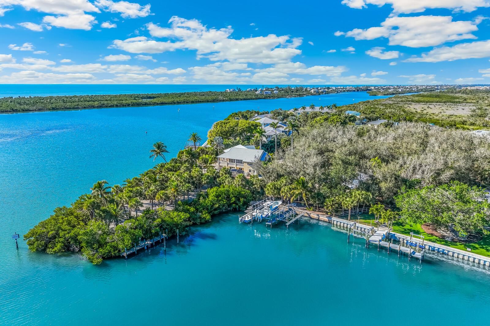 Behind a gated, palm-lined drive, this custom Cape Haze estate unfolds across two expansive parcels totaling 2.62 acres, offering an uncommon sense of scale, privacy, and direct waterfront access on Lemon Bay. Built by J & J Homes for the builder himself, the residence reflects a level of craftsmanship and material integrity rarely found in the market.

The main living level is organized around a light-filled great room, where a wood-lined cathedral ceiling and custom built-ins frame uninterrupted views of the bay. Walls of glass open to a covered veranda, creating a seamless connection between interior spaces and the surrounding landscape.

The kitchen is both refined and functional, appointed with custom wood cabinetry, granite countertops, under-cabinet lighting, a hand-painted sink, copper range hood, KitchenAid appliances, and a Sub-Zero refrigerator. A breakfast nook enhance everyday ease, while a formal dining room with crown molding and a sculptural niche is designed for more considered gatherings.

The primary suite is positioned as a private retreat, featuring a double tray ceiling with layered crown molding, an expansive walk-in closet supplemented by two additional closets, and a spa-like bath with an extended granite vanity, gold-plated fixtures, a walk-in shower, and a Jacuzzi soaking tub.

A dedicated office with leaded glass French doors and custom built-in cabinetry offers a quiet, purposeful workspace. A guest suite with water views, balcony access, and an adjacent marble-appointed bath provides comfort and privacy for visitors. A well-placed powder room and a thoughtfully designed laundry room complete the main level.

Outdoors, a heated screened pool and spa overlook Lemon Bay, accompanied by a convenient half bath. The property’s 530 feet of concrete seawall supports exceptional boating infrastructure, including a 16,000-pound lift, a separate 10,000-pound covered lift, Trex dock, fishing station with water and electric, and a dedicated launch for kayaks and paddleboards. Deep-water access to the Intracoastal Waterway is immediate, with Don Pedro Island State Park just across the lagoon.

Additional features include zoned HVAC, tankless water heater, new electrical panel, an attached side-entry three-plus-car garage, and a 1,500+ square foot air-conditioned detached garage and workshop with epoxy flooring.

A composed and enduring waterfront estate, defined by craftsmanship, privacy, and a rare depth of waterfront presence.