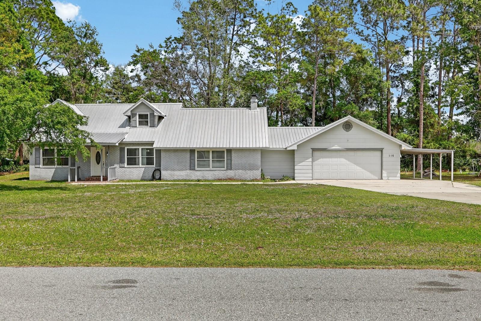 Situated on a spacious 1-acre lot, this charming Palatka property offers the perfect blend of comfort, privacy, and room to grow. The home features new flooring throughout, a cozy fireplace, and accent walls that add warmth and character to the living space. The primary bedroom is conveniently located on the first floor for added ease and functionality. Enjoy relaxing on the screened porch overlooking the expansive yard, creating a peaceful and private outdoor retreat. With plenty of space to spread out, the property includes a 2 car garage, carport, and an additional rear carport--ideal for extra vehicles, boats, equipment, or storage. The large lot provides endless possibilities for outdoor living, hobbies, or future expansion. Located just down the street from the new Kelly Smith Elementary School currently under construction, this home offers both convenience and long-term value. Well and septic in place.