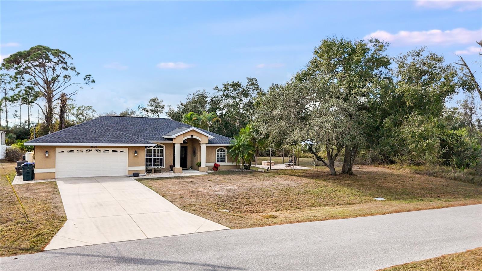 *3D VIRTUAL TOUR* Welcome to this absolutely gorgeous, well-maintained 3 bedroom, 2 bath, 2 car garage, CUSTOM POOL home, perfectly situated on a DOUBLE LOT, with over 2,000 square feet of living space. This home offers the ideal blend of comfort, space, location & value. As you arrive, you are greeted by tasteful exterior lighting, gutters, & lush landscaping accented with pebble rock, palm trees, & vibrant flowering plants. The cleared lot next door feels straight out of a fairy tale, featuring an open paver patio with a firepit & string lights for evening ambiance. A majestic oak tree provides shade & charm, creating the perfect spot for a tire swing, quiet relaxation, or memorable gatherings. Step inside & prepare to be impressed by the expansive living areas & beautiful architectural details. High vaulted ceilings, crown molding, updated light fixtures, coastal-inspired paint colors, faux wood blinds, & a central vacuum system enhance the home throughout. The inviting living room welcomes you from the foyer & offers a wonderful space to relax with friends & neighbors. The open-concept chef’s kitchen is thoughtfully designed & features granite countertops, solid wood cabinetry with crown molding, stainless steel appliances, a closet pantry, plant shelves, & a center island accented by an industrial-style light fixture. The island provides ample prep space while the extended breakfast bar offers additional seating overlooking the main living areas, perfect for staying connected during meals and entertaining. A cozy breakfast nook sits nearby, ideal for enjoying your morning coffee while taking in peaceful backyard views. A formal dining room showcases a striking pendant light & large front windows that allow natural sunlight to fill the space, creating an elegant setting for home-cooked meals & special occasions. After dinner, head to the spacious family room, perfect for movie nights or relaxing evenings at home. The primary suite is a true retreat, offering dual walk-in closets, private lanai access, & a spa-like en-suite bathroom. The primary bath features dual vanities & a Roman walk-in shower with built-in bench & aquarium window. On the opposite side of the home, the desirable split bedroom floor plan provides privacy for guests. Each guest bedroom includes a window, ample closet space, carpeting, & ceiling fan. The guest bathroom doubles as a pool bath & offers a vanity, mirror, light fixture, tub & shower combination. Just off the kitchen is an interior laundry room along with an additional utility room complete with a utility sink, shelving, & washer and dryer hookups. Sliding glass doors lead to your private backyard oasis, the epitome of Florida living. The oversized screened lanai includes a covered area ideal for outdoor dining & relaxing. Take a refreshing dip in the custom heated saltwater pool featuring a waterfall & in-ground spa. An additional open lanai space provides even more room to entertain, grill, gather around the firepit, relax in a hammock, or soak up the Florida sunshine. No deed restrictions, no HOA fees, & no flood insurance required. Conveniently located in North Port, close to shopping, dining, golfing, fishing, entertainment, & medical facilities. Nearby spring training stadiums, award-winning beaches, Wellen Park, & the new Sunseeker Resort make this location even more desirable. Don't wait! This home truly has it all. Schedule your showing today & start living the Florida lifestyle!