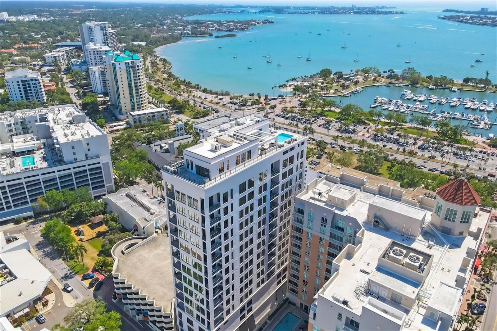 Experience refined downtown living from the 15th floor of The DeMarcay, one of Sarasota's premier luxury condominium residences. Perfectly positioned in the heart of downtown, this exceptional two-bedroom, two-bath residence offers the ultimate walkable lifestyle, placing world-class dining, boutique shopping, art galleries, theaters, the Sarasota Opera, Whole Foods, the Saturday Farmers Market, and the city's vibrant cultural scene just outside your door. Just a short stroll away, Sarasota Bay, Marina Jack, Bayfront Park, and O'Leary's Tiki Bar provide endless opportunities to enjoy waterfront dining, boating, and spectacular Gulf Coast sunsets.
Inside, the residence showcases sophisticated contemporary design with an open-concept floor plan highlighted by a stunning chef's kitchen featuring quartz countertops, a waterfall island, and seamless flow into the dining and living areas. Floor-to-ceiling windows and the private terrace capture beautiful city views along with a picturesque peek of Sarasota Bay. A custom-built entertainment wall and elegant dry bar with wine refrigeration create the perfect setting for entertaining, while porcelain tile flooring, designer lighting, and premium finishes elevate every space. The spacious primary suite offers a custom walk-in closet and a beautifully appointed spa-inspired bath.
Residents of The DeMarcay enjoy an exceptional luxury lifestyle with concierge service, valet parking, the secure Butterfly entry system, a state-of-the-art fitness center, owner's storage, and a spectacular rooftop amenity level featuring a resort-style pool, outdoor kitchen, club room, and panoramic views of Sarasota's skyline and bay. This is a rare opportunity to enjoy sophisticated, maintenance-free living with the very best of downtown Sarasota just steps from your front door.