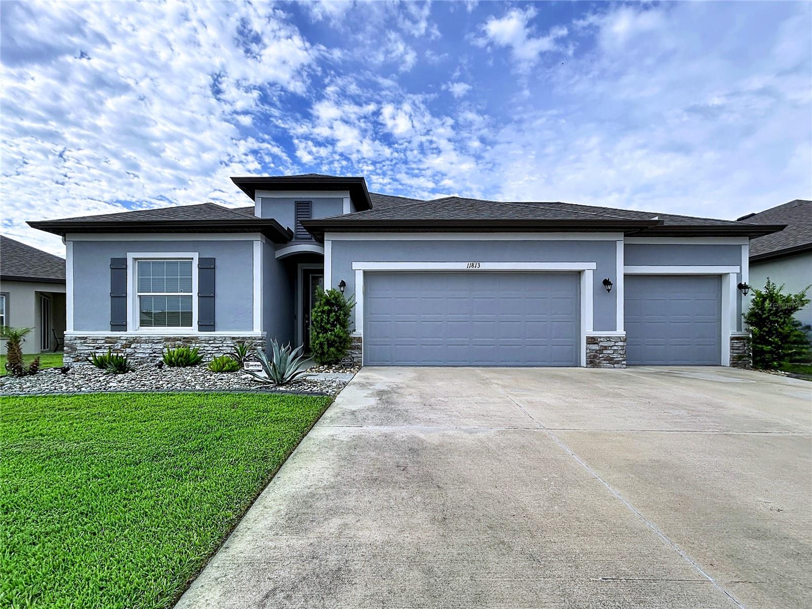 One or more photo(s) has been virtually staged. THIS IS IT!  Welcome HOME to this stunning “Miramar” floor plan by Maronda Homes LOADED with premium UPGRADES and showcases beautiful Floridian-style architecture with stone accents, decorative shutters, and exceptional curb appeal.  This AMAZING HOME is located in the highly sought-after Mirada LAGOON Community, the nation’s largest 15.2-Acre Crystal Lagoon and one of Florida’s TOP-selling master-planned communities.  STEP through the custom 8’ Full-Lite entry door into an elegant FOYER featuring a double tray ceiling with crown molding. The thoughtfully designed OPEN-CONCEPT layout seamlessly connects the MAIN LIVING areas, creating the perfect space for entertaining and everyday living. Ceramic wood-look tile flooring and crown molding enhance the main living areas throughout the home.  The Kitchen is truly the HEART of the HOME, highlighted by an OVERSIZED 9’ Carrera Marmi quartz island with breakfast bar seating, 42” upper cabinets with crown molding, soft-close drawers, subway tile backsplash, and pantry with custom built-in shelving. The Dining area is accented with decorative mirrored wall panels, adding a touch of sophistication for special gatherings and holidays.  The spacious Living Room features triple sliding glass doors that open to your PRIVATE BACKYARD OASIS.  Enjoy Florida living year-round with a covered lanai, extended screened patio, additional open patio space.  The expansive backyard offers endless possibilities for future outdoor enhancements.  Privately located at the rear of the home, the luxurious OWNER'S SUITE features a tray ceiling with crown molding and a custom walk-in closet system complete with built-in drawers, shelving, and storage baskets.  The spa-inspired EN SUITE bathroom includes quartz make up vanity, soft-close cabinetry, a soaking tub, floor-to-ceiling tiled walk-in shower, and linen storage.  This 3-Way Split Floor Plan provides excellent privacy and flexibility.  Three generously sized secondary bedrooms are positioned toward the front of the home with abundant natural light and ample closet space.  Bedrooms two and three share a beautifully appointed secondary bathroom featuring a quartz vanity and tiled tub/shower combo with framed sliding glass doors.  The fourth bedroom offers versatility as a home office, flex room, or guest suite.  The inside Laundry Room has cabinets and includes LG Thin Q washer & dryer.  •FEATURES: •Smart Home IQ system controlling alarm, thermostat, and video doorbell •Additional windows and lighting in the Living Room & Owner’s Suite •Sliding mirrored closet doors in secondary bedrooms and En-Suite Bathroom •Blackout Roman shades & modern horizontal blinds •Graceland Oak laminate flooring in secondary bedrooms •Extended Screened Enclosure with lighting •6' PVC Privacy Fence •Premium epoxy-coated 3 Car Garage, front porch, patio, and walkways •Landscape curbing and low-maintenance gardens •Full gutter system.  Residents of Mirada enjoy RESORT-STYLE amenities including a dog park, playground, GOLF CART-friendly streets, and miles of scenic biking, walking, and running trails. Conveniently located with EASY access to SR 52, I-75, I-275, I-4, and downtown Tampa.  Nearby golf courses, medical facilities, schools, and premier dining and shopping at Tampa Premium Outlets, The Grove at Wesley Chapel, and The Shops at Wiregrass.  This exceptional HOME combines luxury, comfort, and lifestyle — schedule your PRIVATE showing today!