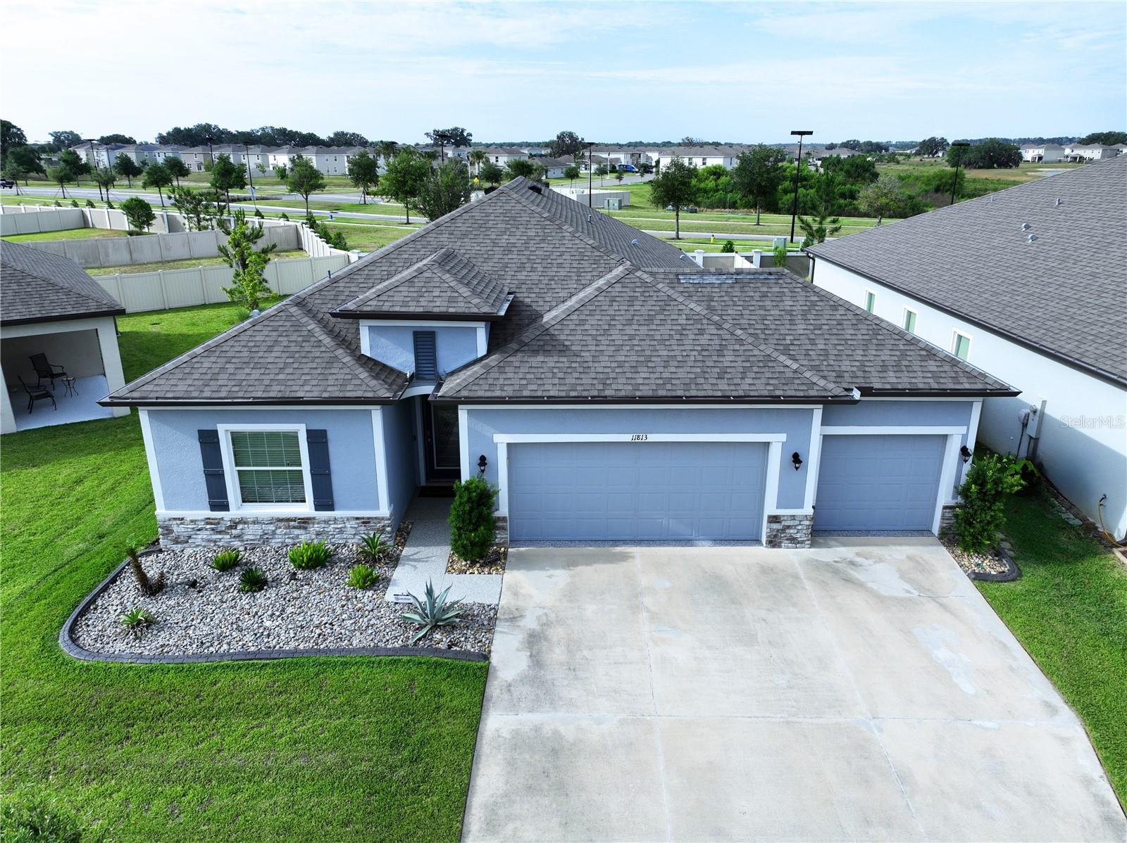 One or more photo(s) has been virtually staged. THIS IS IT!  Welcome HOME to this stunning “Miramar” floor plan by Maronda Homes LOADED with premium UPGRADES and showcases beautiful Floridian-style architecture with stone accents, decorative shutters, and exceptional curb appeal.  This AMAZING HOME is located in the highly sought-after Mirada LAGOON Community, the nation’s largest 15.2-Acre Crystal Lagoon and one of Florida’s TOP-selling master-planned communities.  STEP through the custom 8’ Full-Lite entry door into an elegant FOYER featuring a double tray ceiling with crown molding. The thoughtfully designed OPEN-CONCEPT layout seamlessly connects the MAIN LIVING areas, creating the perfect space for entertaining and everyday living. Ceramic wood-look tile flooring and crown molding enhance the main living areas throughout the home.  The Kitchen is truly the HEART of the HOME, highlighted by an OVERSIZED 9’ Carrera Marmi quartz island with breakfast bar seating, 42” upper cabinets with crown molding, soft-close drawers, subway tile backsplash, and pantry with custom built-in shelving. The Dining area is accented with decorative mirrored wall panels, adding a touch of sophistication for special gatherings and holidays.  The spacious Living Room features triple sliding glass doors that open to your PRIVATE BACKYARD OASIS.  Enjoy Florida living year-round with a covered lanai, extended screened patio, additional open patio space.  The expansive backyard offers endless possibilities for future outdoor enhancements.  Privately located at the rear of the home, the luxurious OWNER'S SUITE features a tray ceiling with crown molding and a custom walk-in closet system complete with built-in drawers, shelving, and storage baskets.  The spa-inspired EN SUITE bathroom includes quartz make up vanity, soft-close cabinetry, a soaking tub, floor-to-ceiling tiled walk-in shower, and linen storage.  This 3-Way Split Floor Plan provides excellent privacy and flexibility.  Three generously sized secondary bedrooms are positioned toward the front of the home with abundant natural light and ample closet space.  Bedrooms two and three share a beautifully appointed secondary bathroom featuring a quartz vanity and tiled tub/shower combo with framed sliding glass doors.  The fourth bedroom offers versatility as a home office, flex room, or guest suite.  The inside Laundry Room has cabinets and includes LG Thin Q washer & dryer.  •FEATURES: •Smart Home IQ system controlling alarm, thermostat, and video doorbell •Additional windows and lighting in the Living Room & Owner’s Suite •Sliding mirrored closet doors in secondary bedrooms and En-Suite Bathroom •Blackout Roman shades & modern horizontal blinds •Graceland Oak laminate flooring in secondary bedrooms •Extended Screened Enclosure with lighting •6' PVC Privacy Fence •Premium epoxy-coated 3 Car Garage, front porch, patio, and walkways •Landscape curbing and low-maintenance gardens •Full gutter system.  Residents of Mirada enjoy RESORT-STYLE amenities including a dog park, playground, GOLF CART-friendly streets, and miles of scenic biking, walking, and running trails. Conveniently located with EASY access to SR 52, I-75, I-275, I-4, and downtown Tampa.  Nearby golf courses, medical facilities, schools, and premier dining and shopping at Tampa Premium Outlets, The Grove at Wesley Chapel, and The Shops at Wiregrass.  This exceptional HOME combines luxury, comfort, and lifestyle — schedule your PRIVATE showing today!