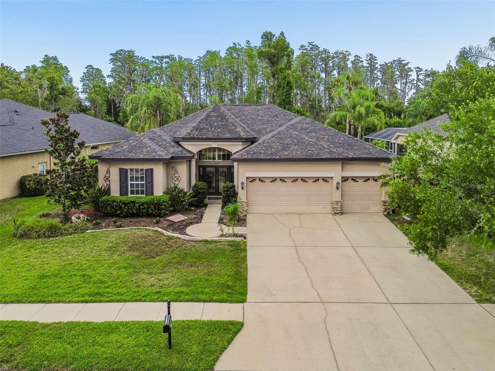 Live the Florida Lifestyle in this spacious 4 bedroom POOL HOME – NO CDD! Welcome to a home that truly captures the essence of relaxed Florida living. Tucked in the desirable gated community of the Savanna at Plantation Palms, this beautifully maintained 4 bedroom plus office, 3 bath, 3 car garage pool home offers the perfect blend of comfort, character and convenience.  Upon entry you will encounter separate formal living and dining areas with crown molding and decorative accents walls providing a welcoming atmosphere. The spacious kitchen with eat in kitchen space and open family room with fireplace provides a central hub perfect for gathering and entertaining. Elegant primary suite features crown molding, hardwood floors, and dual closets with custom built in closet organizers. The split bedroom floor plan allows for plenty of privacy. Additional office space features large windows with beautiful views of the pool and rear conservation. Inside laundry room with utility sink and plenty of cabinets for ample storage. The family room sliding doors lead to the expansive screened in lanai offering a seamless transition between indoor and outdoor spaces, providing another inviting space for socializing and enjoying evenings outdoors. Enjoy Florida living at its best while relaxing in your sparkling heated pool with your own private backyard oasis boasting fruit and avocado trees and conservation views. Enjoy peace of mind with these additional updates: new roof and HVAC 2024, water heater in December 2022. Plantation Palms offers no CDD fees and easy access to schools, Wiregrass Mall, Tampa Premium Outlets, dining, and major highways (US 41, SR 54, I75/275, Suncoast Expressway).