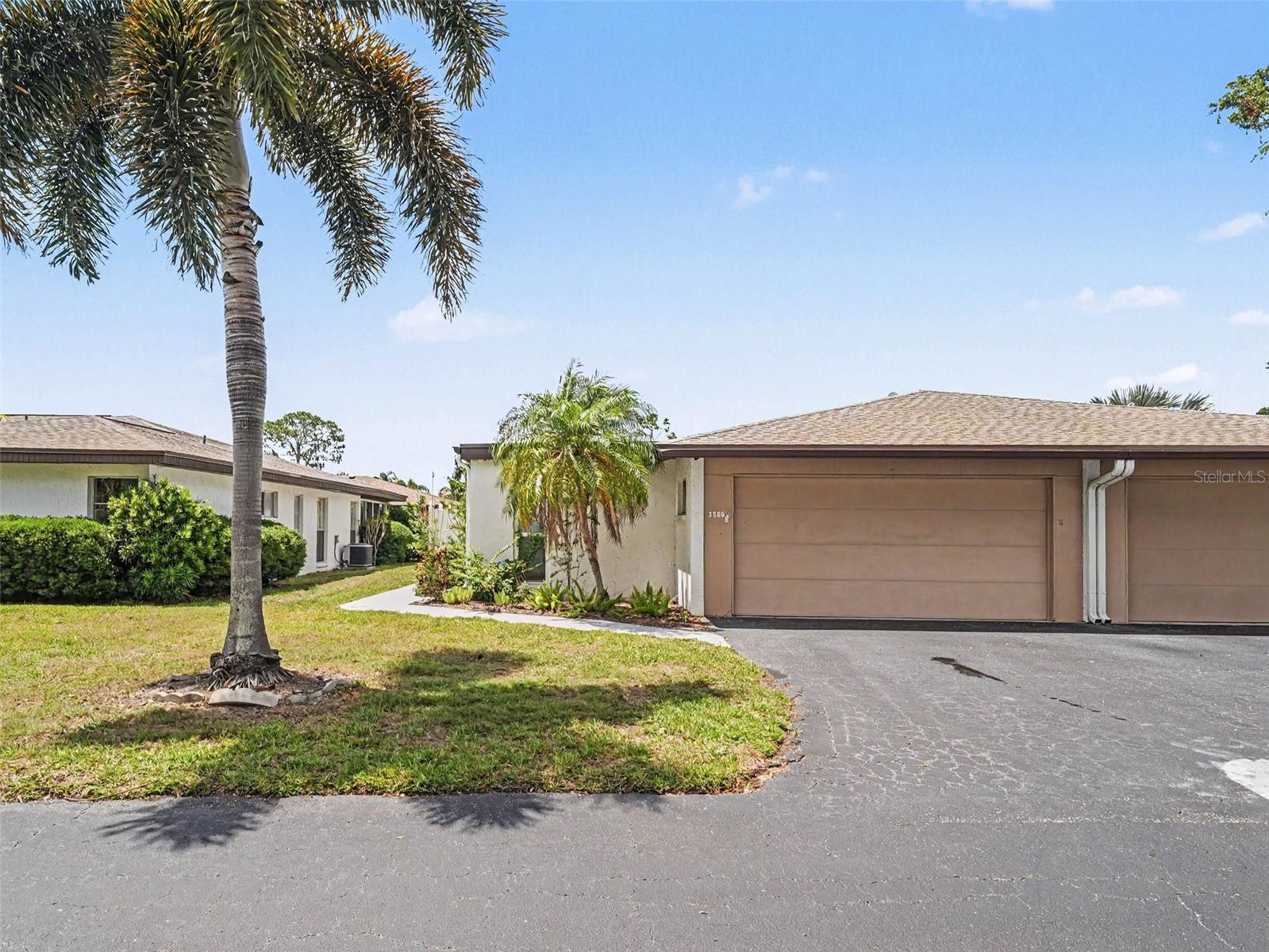 Welcome to this charming condo/villa located in the highly desirable Village in the Pines North, a friendly 55+ community in the heart of Sarasota. This spacious 2-bedroom, 2-bathroom residence features a split floor plan, offering privacy and comfort for both owners and guests. The bright kitchen is equipped with stainless steel appliances, and the home includes a convenient laundry room, just off the garage entry, with washer and dryer plus plenty of room for storage.  A standout feature is the elegant Waterford crystal pineapple chandelier that adds a touch of sophistication to the dining area. Enjoy Florida living year-round in the large, enclosed patio, perfect for relaxing, entertaining, or creating a cozy garden retreat. There is an additional, fenced-in patio just off the kitchen, perfect for enjoying a cup of coffee in the morning or dinner outside as well as a courtyard off of the dining room, perfect for plants or a garden.  The attached 2-car garage provides ample storage and convenience. This home offers tremendous potential and is priced to sell, making it an excellent opportunity for buyers looking to personalize a space in a wonderful community. Residents enjoy access to a sparkling community pool and clubhouse, just minutes from Sarasota’s beautiful beaches, top-rated restaurants, shopping, and easy highway access.