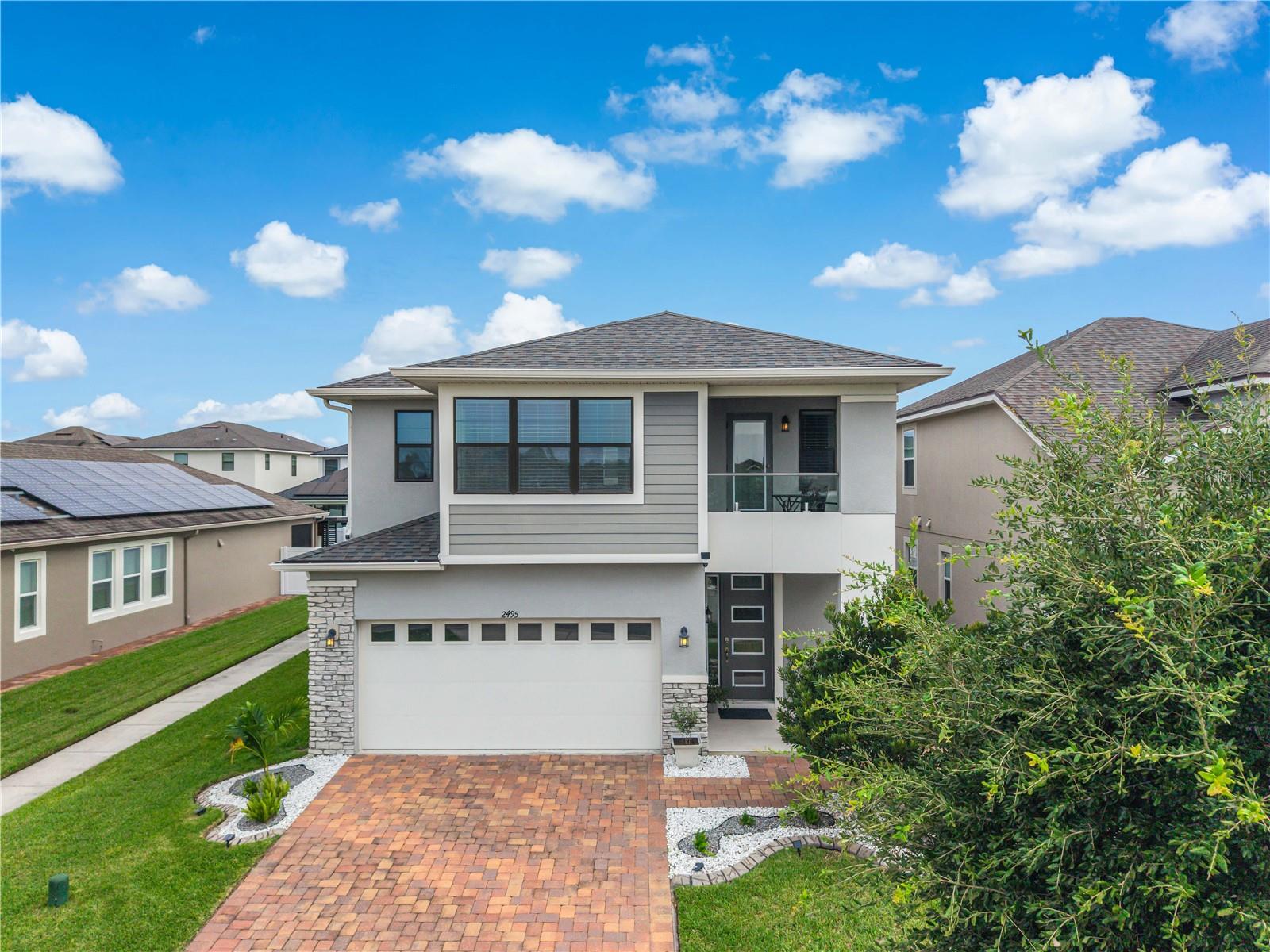 Welcome to this beautifully upgraded Mattamy-built home in the sought-after guard-gated community of Tapestry. This move-in-ready two-story residence offers 4 bedrooms, 2.5 bathrooms, a dedicated study downstairs, spacious loft upstairs, formal dining room, and an open-concept great room designed for everyday living and entertaining. The chef-inspired kitchen features a large center island and overlooks the main living area, creating the perfect gathering space. Upstairs, enjoy a private tiled balcony, while outside you'll find a screened lanai, extended 5-foot paver patio, paved side access, and a PVC-fenced backyard ideal for relaxing or entertaining. The oversized 2-car garage includes overhead storage and additional depth to accommodate larger vehicles. Recent upgrades include an LG Smart Steam washer and dryer (less than one year old) and a Samsung Bespoke refrigerator with filtered water, ice maker, and Beverage Center. Residents of Tapestry enjoy exceptional resort-style amenities, including a 24-hour guard-gated entrance, lakefront clubhouse, resort pool with splash features, fitness center, dog park, playgrounds, walking trails, and community event space. Conveniently located just minutes from The Loop, major highways, Orlando International Airport, world-famous attractions, shopping, and dining, this home offers the perfect combination of luxury, comfort, and convenience