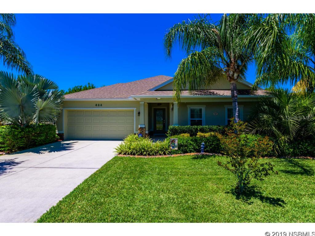 Beautiful 4/2/2 split floorplan home in the coveted subdivision of Sugar Mill Gardens in New Smyrna Beach! You will love the pristine front yard and curb appeal as you walk up the driveway to an inviting front porch. The leaded glass front door accents the entry to the foyer as you enter the charming house. Inside, you will be inspired as your senses adjust to the warm, tasteful colors and begin to picture your furnishings arranged in the open concept living area. 10-feet high ceilings contribute to the openness of the dining, living and kitchen areas. Hand-scraped bamboo flooring stretches from the foyer through the living area into the master bedroom. His and hers walk-in closets in the master....There's ceramic tile in all the wet areas and carpet in the 3 bedrooms. The kitchen boasts of 42-inch cabinets, granite countertops and stainless-steel appliances. All appliances convey to the buyer, as well as the washer and dryer. Plenty of pantry space in the kitchen. The inside laundry room includes a deep utility sink and cabinets over the washer/dryer. The kitchen breakfast nook overlooks the back screened-in patio and the lush backyard vegetation. There's bougainvillea, confederate jasmine, roses, banana tree, avocado tree, sea grapes, bird of paradise, and many other trees and flowering plants to enjoy. The property backs up to a conservation area, so you won't ever have to worry about anyone building behind you. The woods are home to many birds and small animals to enjoy. The patio has been extended on both sides of the back porch with pavers which makes it nice for barbeques with family and friends. Attractive vinyl fencing encases the home for added privacy as well as securing the little ones and fur babies. Whole house gutters are included as well. ADT security system installed and ready for your own security needs. Transferable termite bond that was just recently purchased and doesn't expire till March of 2029! ;Water: City