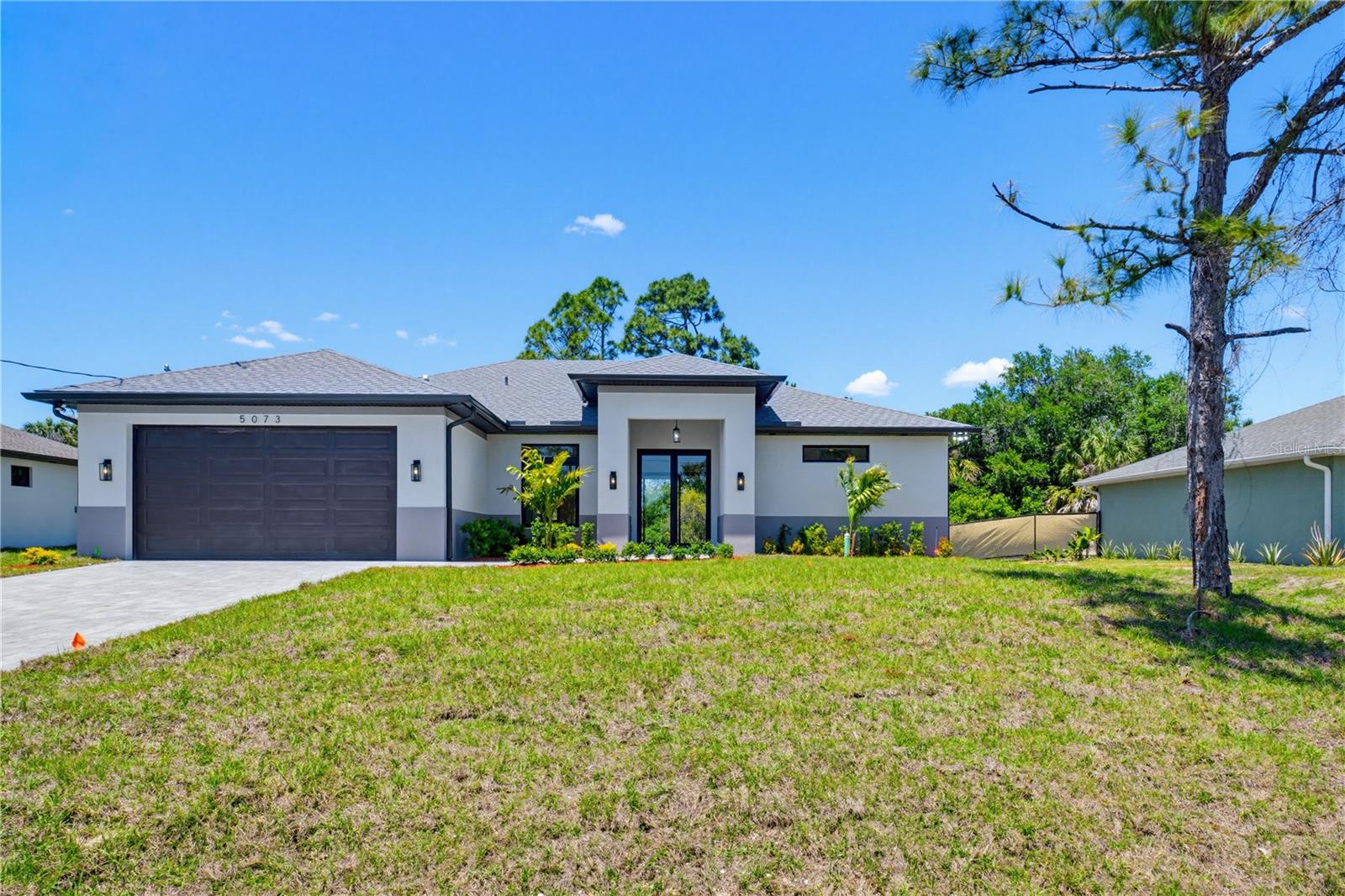 Virtually Staged. Step into luxury at 5073 Hightower Road in North Port, Florida, where thoughtful design and premium finishes come together to create the perfect Southwest Florida lifestyle. As you arrive, you’re welcomed by a beautiful paver driveway and elegant French doors that make a stunning first impression before you even step inside.

Once through the front entrance, the home immediately opens up with soaring 12-foot ceilings and detailed tray ceilings throughout the main living areas, creating a bright and spacious atmosphere that feels both warm and sophisticated. Oversized hurricane impact windows allow natural light to pour throughout the home while providing peace of mind year-round.

At the center of the home is a beautifully designed chef’s kitchen featuring a dramatic waterfall island, double-stacked cabinetry, and high-end finishes that blend style with functionality. Whether you’re entertaining guests or enjoying a quiet night at home, this open-concept layout was built to bring people together.

Just off the main living space, you’ll find a dedicated office/den area that offers the flexibility today’s buyers are searching for — perfect for working from home, a playroom, fitness space, or additional lounge area.

The home continues to impress as you step out onto the tiled lanai, creating the ideal outdoor space to relax and enjoy Florida living. Even the garage was designed with quality in mind, featuring sleek epoxy-coated floors that add both durability and a polished finish.

Built by PadPath, this 3-bedroom, 2-bathroom home is packed with the affordable luxury upgrades buyers across Southwest Florida are looking for. Modern design, premium craftsmanship, and incredible value all come together in one exceptional North Port home.