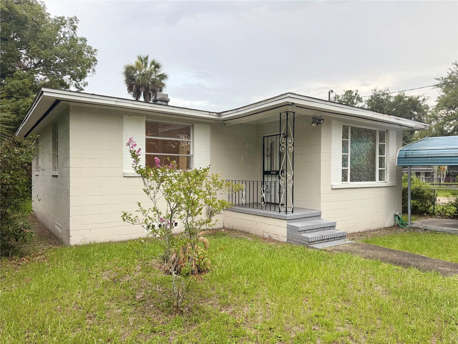 Welcome to this beautifully updated 2-bedroom, 1-bathroom concrete block home nestled in Jacksonville. Whether you’re a first-time buyer or savvy investor looking for a turnkey rental, this property checks all the boxes. Step inside to find gleaming refinished hardwood floors throughout the living, kitchen and bedroom areas, fresh interior paint, and an abundance of natural light from large windows. The open-concept living and dining area flows seamlessly into the fully renovated kitchen, featuring white shaker cabinets, granite countertops, a breakfast bar, and stainless steel appliances — including a refrigerator and range.
The spacious primary bedroom boasts dual closets and a ceiling fan. The updated bathroom shines with modern tile, a sleek vanity, contemporary fixtures, and a tub/shower combo with a rain shower head. Some highlights that stand out are the in-unit laundry room with washer and dryer included, a covered carport for convenient parking, central heating and air and a fully fenced yard that’s great for pets or entertaining. The seller has a survey on hand and a recent 4-point and wind mitigation report they are happy to disclose. Check out the location because this home is conveniently located in Jacksonville with easy access to shopping, dining, and major roadways. Move-in ready and priced to sell!