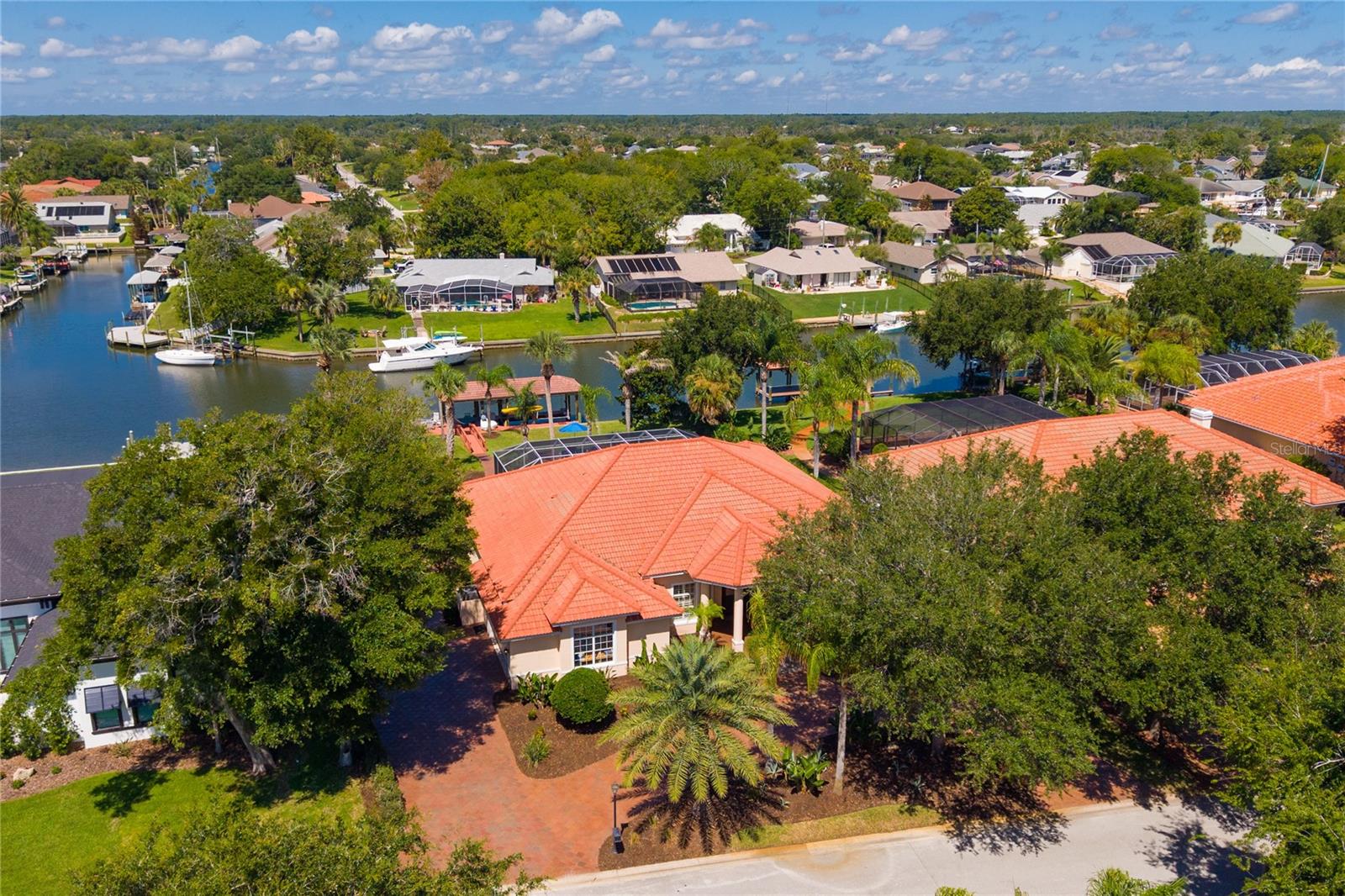 Luxury Waterfront Estate in The Sanctuary – A Boater’s Ultimate Paradise
Welcome to your ultimate winter escape or permanent paradise in The Sanctuary, one of Palm Coast’s most exclusive gated communities. Tucked away along the Intracoastal Waterway amidst pristine lakes and winding trails under majestic old oak trees, this spectacular one-story Mediterranean estate offers 2,947 sq. ft. of refined luxury, privacy, and unparalleled waterfront living.
Exquisite Interior Living
From the paved circular driveway and side-entry 2-car garage, step inside to a breathtaking foyer showcasing 12-foot tray ceilings and a seamless, sun-drenched open floor plan. Featuring 4 spacious bedrooms (one as office space) and 2 bathrooms the home beautifully balances grand entertaining spaces with private retreats. The gourmet kitchen is a chef’s dream, boasting high-end 42” solid wood cabinetry, rich granite countertops, and an intuitive flow into the expansive dining and living areas. Enjoy upscale finishes throughout, including rich ceramic tile and wood flooring in the main living areas, with plush carpet in the bedrooms. The primary suite serves as a peaceful oasis, complete with a spa-like ensuite bath featuring double vanities, an expansive walk-in shower, a separate jacuzzi tub, and a private water closet all opening up to the lanai.
A Boater’s Dream Backyard
The crown jewel of this estate is its world-class outdoor setup, situated on a deep-water canal with 100 feet of prime frontage and no bridges to the Intracoastal Waterway (Sailboat Country with a ˜ 5.5 ft draft). Host up to a 60’ vessel on one of the community's largest docks (55’ length), or park your dayboat on the 10,000-lb lift inside the covered boathouse (built for up to a 27’ boat).
Exceptional Resort-Style Outdoor Entertaining
 Screened Lanai & Pool: Unwind by the pristine pool or heated in-ground spa, surrounded by a freshly sealed paver deck.
 Summer Kitchen: Entertain effortlessly with a built-in outdoor refrigerator, sink, and granite bar with comfortable seating.
 Waterfront Patio: Step outside the screen to a secondary paved patio, perfect for lounging in Adirondack chairs and watching boats glide down the wide canal.
Recent Premium Infrastructure Updates
Move in with absolute peace of mind knowing the home's big-ticket items have been completely modernized:
 2023: New 3-Zone HVAC system & New Pool Pump
 2025: New 250-Gallon Propane Tank & New Pool/Spa Heater
 2026: Professionally Sealed Exterior Pavers
The Ultimate Location & Lifestyle
Whether you are a northern retiree looking to escape the cold or seeking a refined luxury second home, The Sanctuary offers a secure, vibrant community of just 175 homes. Enjoy absolute tranquility while remaining just minutes from pristine Atlantic beaches, championship golf courses, and premier shopping. With easy access to I-95, the historic charm of St. Augustine, the energy of Daytona Beach, and metropolitan Jacksonville are all just a short drive away.
Opportunities with this caliber of waterfront access, dock size, and pristine condition are truly rare. Schedule your private tour today.