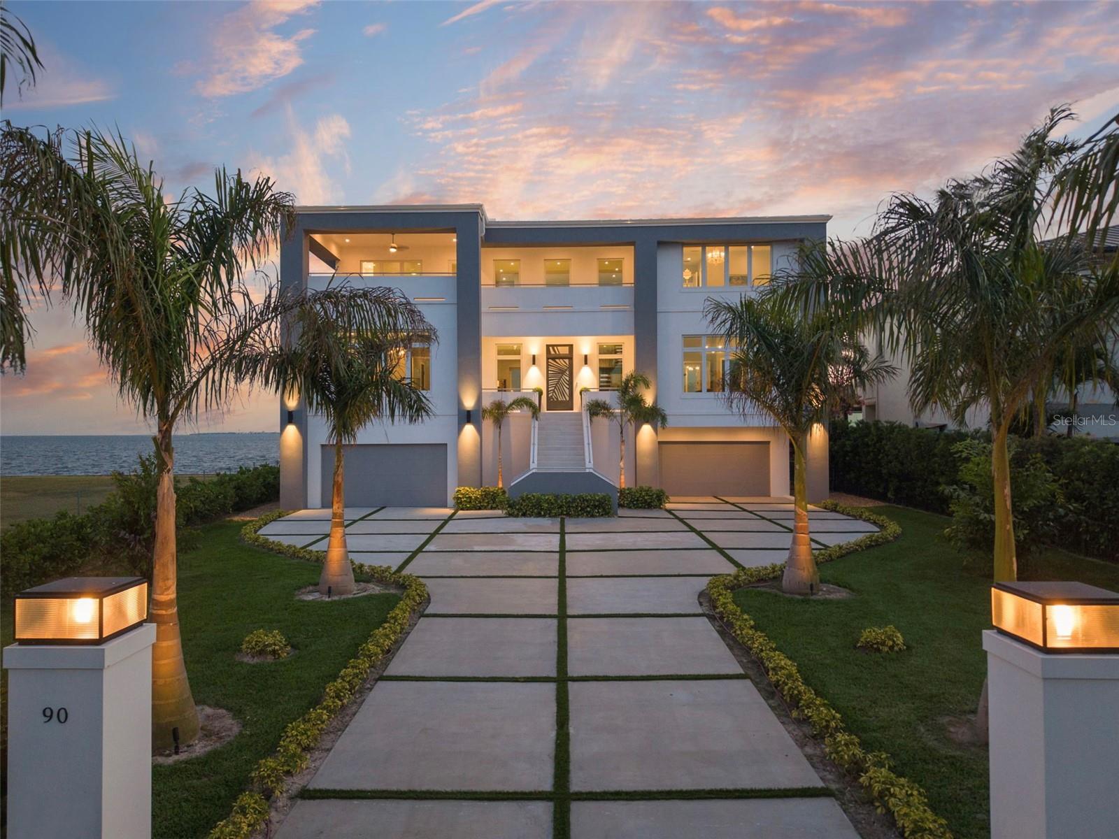 Introducing Oceara, a landmark of bold design, superior engineering and refined coastal living on Tampa’s Billionaires Row in Davis Islands. Over 12,000 square feet under roof, and completed in late 2024, this architectural fortress is constructed of poured concrete and steel, elevated to meet FEMA codes, anchored by 40-foot-deep pilings driven to bedrock, and topped with a riveted metal roof and full-impact glass throughout. Go inside to a grand double-height foyer, grounded in architectural sophistication, with a floating glass-and-metal staircase revealing uninterrupted water views of Tampa Bay. Oceara features six luxurious private suites, a game room, elevator, and an expansive garage accommodating eight or more vehicles. Designed to embody enduring strength and contemporary design, the home offers oversized covered balconies that invite year-round enjoyment of outdoor living in the gentle coastal breeze. Set on Davis Islands, a self-contained island offering everyday essentials, charming cafes and home to Tampa General Hospital. This golf cart community also features a marina, beach, dog park and convenient access to nearby Davis Islands Airport. Just minutes from downtown Tampa, Oceara combines ultimate luxury with rare accessibility. The resort-style pool, like the home itself, is supported by deep pilings for lasting peace of mind. From sunrise to sunset, Oceara redefines elevated waterfront living.  Two rear covered balconies (44-by-12-foot) and a front balcony (approximately 20-by-12-foot). With 100-plus feet of concrete seawall. This home is one of one, like you. Make it yours. Sold furnished.