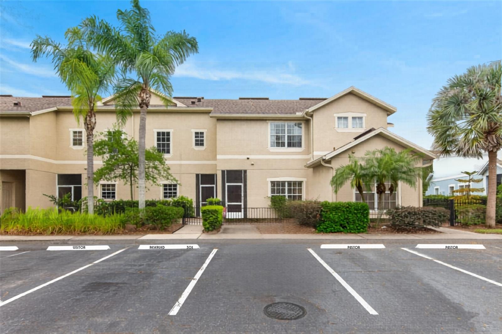 Designed for the buyer who values simplicity, function, and low-maintenance living, this townhome offers a clean layout, great community amenities, and two true ensuite bedrooms — perfect for a professional couple or anyone who wants balanced, flexible space.  The main level features an open living and dining area with wood flooring and a screened-in patio that works beautifully as a quiet morning coffee spot or an easy extension of your living space. The kitchen keeps everything practical and streamlined with white laminate cabinetry, stainless steel appliances, a closet pantry, an eat-in nook, and a breakfast bar. Laundry is tucked into a convenient downstairs closet.  Upstairs, both bedrooms have their own private bathrooms, giving the home the feel of two primary suites. The main suite includes a well-sized walk-in closet, while the second bedroom offers a built-in closet and its own ensuite — ideal for guests, a roommate, or a dedicated office suite. The screened patio offers just enough outdoor space without the upkeep of a yard, and the decorative iron fencing and mature bushes create a sense of privacy. This is truly maintenance-free living — the HOA covers exterior paint, lawn care, exterior pest control, and the roof. HVAC was replaced in 2022 for added peace of mind. Reserved parking plus plenty of guest spaces make day-to-day life easy. The community amenities are a standout: two pools, a splash pad, basketball courts, pickleball, soccer field, dog park, and a full community center. It’s a neighborhood built for staying active, connecting with others, and enjoying a lifestyle that feels bigger than the square footage.