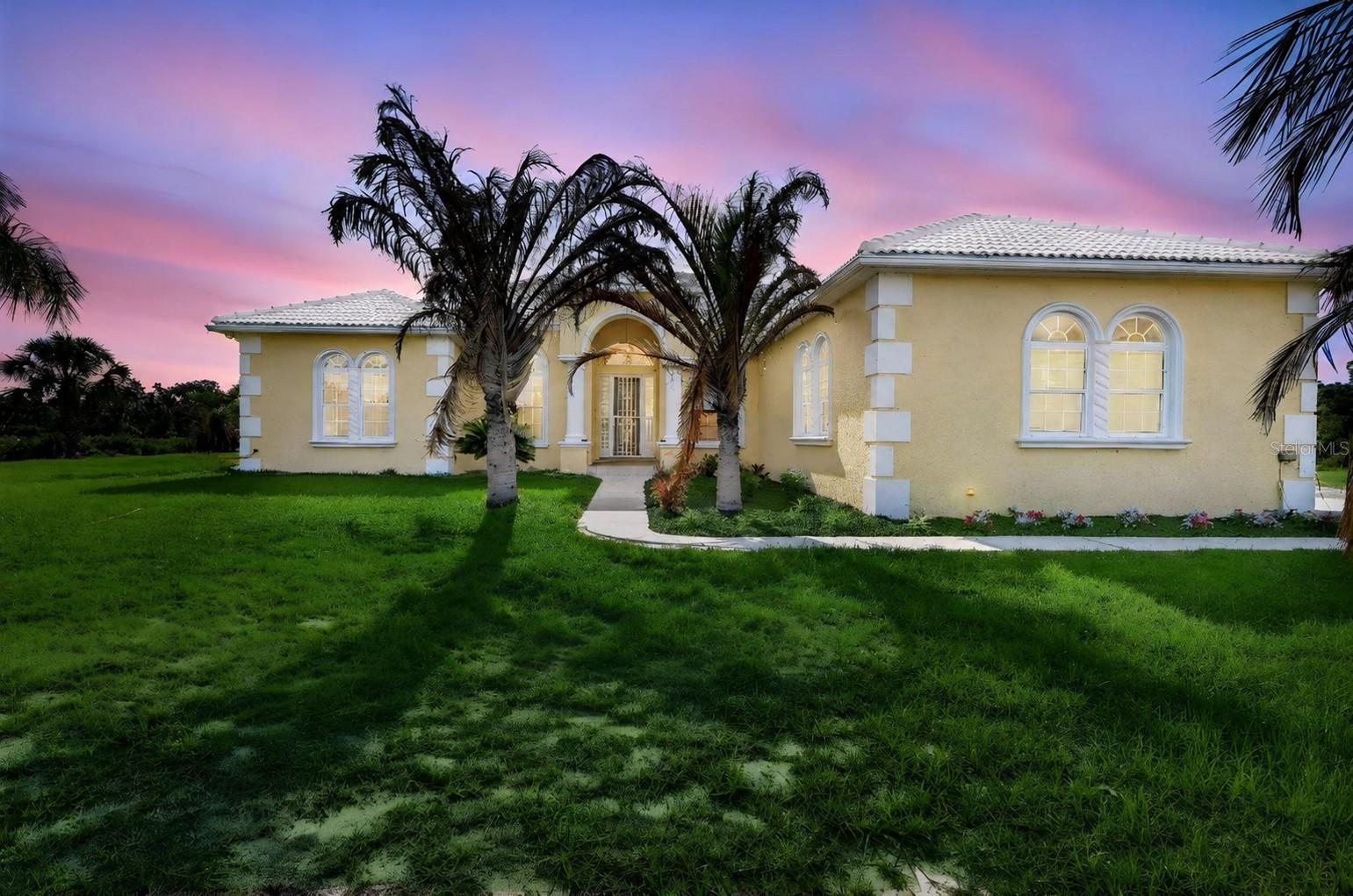 Welcome to a different kind of Florida living — where wide-open skies, room to roam, and luxury comforts all come together on nearly 6 fenced acres in Myakka City. Behind the private coded motorized entry gate, you’ll find a custom-built Mark Cahill home designed for both everyday comfort and the kind of lifestyle people move to the country to enjoy. Whether you’re bringing horses, outdoor toys, or simply looking for more privacy and freedom, this property gives you the space to live the way you want.

Inside, soaring 14-foot ceilings, 8-foot doors, crown molding with accent lighting, and a double tray ceiling create an impressive yet comfortable atmosphere. The living room features built-in shelving and flows toward an aquarium window overlooking the pool, giving you peaceful, unobstructed backyard views from the kitchen nook and main living areas. Gorgeous chandeliers elevate both the formal dining room and kitchen, while all-tile flooring throughout means no carpet anywhere in the home. The flexible floor plan offers 4 bedrooms, 3 baths, formal dining, formal living room, a dedicated office and oversized kitchen with breakfast bar & island.

Step outside and you’ll understand what makes this property special. The saltwater pool features PebbleTec coating, solar heat, and a resistance swim system that allows you to swim against the current for exercise and training right from home. Additional features include a winter safety cover, cool deck surfacing, retractable motorized awning, sunshade, pool bath access and an outdoor shower nearby. You can relax in privacy while enjoying the peaceful surroundings that make country living so appealing.

For buyers needing space for hobbies, equipment, recreational vehicles, or business use, the 900 sq ft workshop is a standout feature with water, power, and approximately half the space under air conditioning. Attached covered parking provides additional room for boats, trailers, or equipment, while the home itself includes a 3-car garage. Nearby recreational opportunities include equestrian trails, boating areas, parks, bow hunting, and a nearby motorsports facility for those who enjoy the active outdoor lifestyle.

This home was built with long-term durability and efficiency in mind, including hurricane-impact windows and garage doors, Icynene insulation for energy efficiency, a Generac generator with buried 250-gallon propane tank, security system with sensors on all doors and windows, and a brand new (2026) $30,000 well system with sulfur filtration and chlorinated pipes for clean drinking water. The barrel tile roof adds timeless curb appeal, while the property has had no flooding and no hurricane damage. An owned 9.5 kW grid-tied solar energy system positioned on the property conveys with the home and helps keep energy costs remarkably low — with no lease to assume.

The community itself offers an equestrian park, riding opportunities, picnic areas near the lake, planned events, and a low HOA fee of just $800 per year. If you’ve been searching for a property where you can spread out, enjoy nature, entertain friends, keep horses, store your toys, and still enjoy upscale finishes and amenities, this is exactly what you’ve been waiting for. Schedule your private showing today and come experience the space, privacy, and lifestyle this exceptional property has to offer!