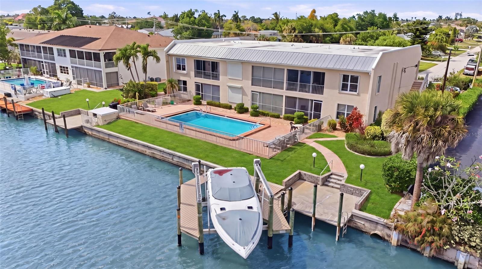 Sun-drenched, waterfront-inspired living meets the vibrant energy of Downtown Cape Coral in this exceptional corner end-unit—an offering that effortlessly blends coastal elegance, investment potential, and an unbeatable location. Perfectly positioned within an intimate, beautifully maintained community of just six residences, this turnkey furnished 2-bedroom, 2-bath condo delivers both privacy and convenience, making it an ideal full-time residence, seasonal retreat, or high-performing rental opportunity. Bathed in natural light from its coveted southern exposure, this bright and airy home showcases a seamless indoor-outdoor lifestyle, highlighted by a spacious screened-in lanai where you can unwind, entertain, and take in breathtaking sunset skies. Every detail invites relaxation, creating a peaceful sanctuary just moments from the excitement of downtown living. Designed with boating enthusiasts in mind, this property offers a rare opportunity to reserve a private boat dock and lift, with renderings available—placing you just a short 10-minute ride from the Caloosahatchee River and open Gulf waters beyond. Whether it’s spontaneous sunset cruises or weekend adventures on the water, this is true Southwest Florida living at its finest. Located just a quick walk or bike ride to Cape Coral’s iconic 47th Terrace, you’ll find yourself immersed in a dynamic waterfront lifestyle filled with top-rated dining, boutique shopping, live entertainment, and year-round events. Yet, within your own residence, you’ll enjoy a quiet, serene atmosphere that feels worlds away. This pet-friendly community—with no age restrictions—offers exceptional flexibility, including seasonal rental options (up to twice per year) or annual leasing. With a strong rental history, this property stands out as a smart and versatile investment. Opportunities like this are rare—where location, lifestyle, and long-term value converge into one unforgettable property. Whether you’re drawn by the boating access, the walkable downtown lifestyle, or the effortless turnkey convenience, this residence is a must-see for those seeking their own slice of paradise in Cape Coral.