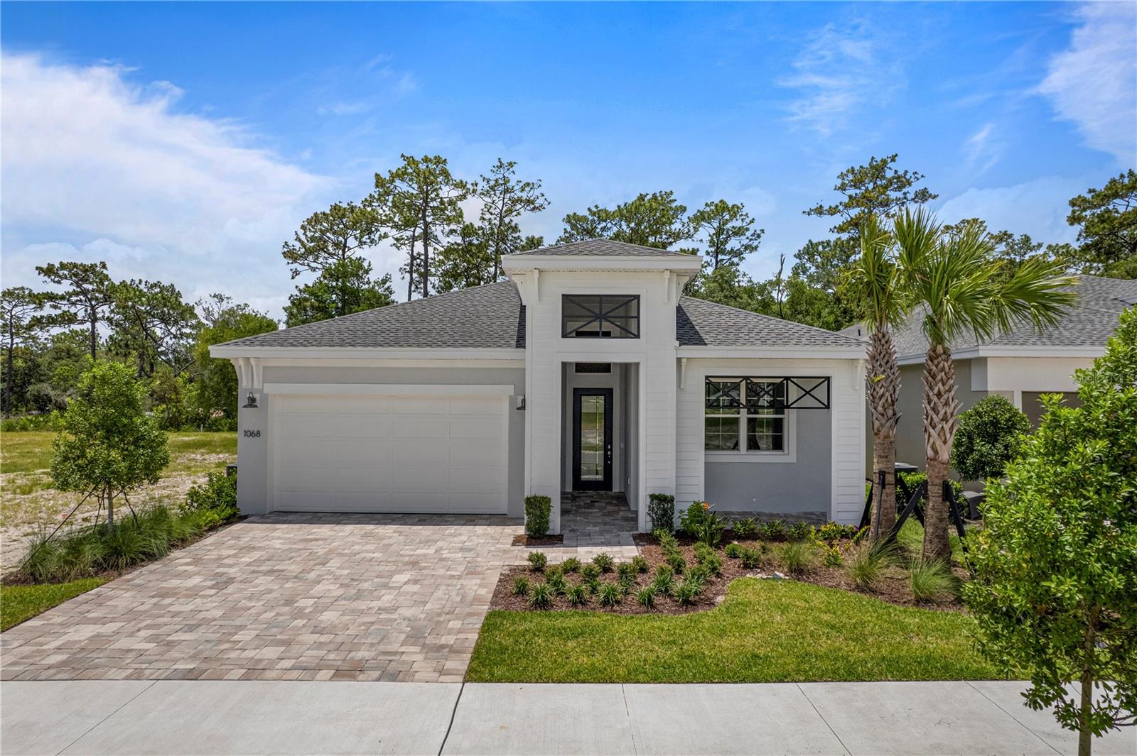 Virtually Staged. Move-in ready and thoughtfully upgraded, this beautifully appointed home offers privacy, functionality, and elegant design throughout. Located near a community park with no rear neighbors and a privacy wall, the homesite provides a peaceful setting to enjoy Florida living. Inside, elevated ceiling heights, tray ceilings, and laminate wood plank flooring throughout the main living areas, flex space, and owner's suite create a spacious and inviting atmosphere. The gourmet kitchen features luxury veined quartz countertops, a large island with knee-wall wrap, artisan beveled tile backsplash, 30" stainless steel electric cooktop, pot and pan cabinet, and full-extension soft-close drawers. The extended owner's suite offers additional living space, while the owner's bath and bath 3 feature frameless glass shower enclosures. A designer glass front door adds curb appeal and welcomes you into the home. The 16' sliding glass door opens to an extended covered lanai, creating seamless indoor-outdoor living. Additional features include summer kitchen pre-wire, laundry tub rough-in, built-in Taexx pest control system, and numerous designer finishes throughout. This move-in ready Madison combines quality craftsmanship, upgraded features, and a private homesite in a desirable location. See Community Home Guides for details.