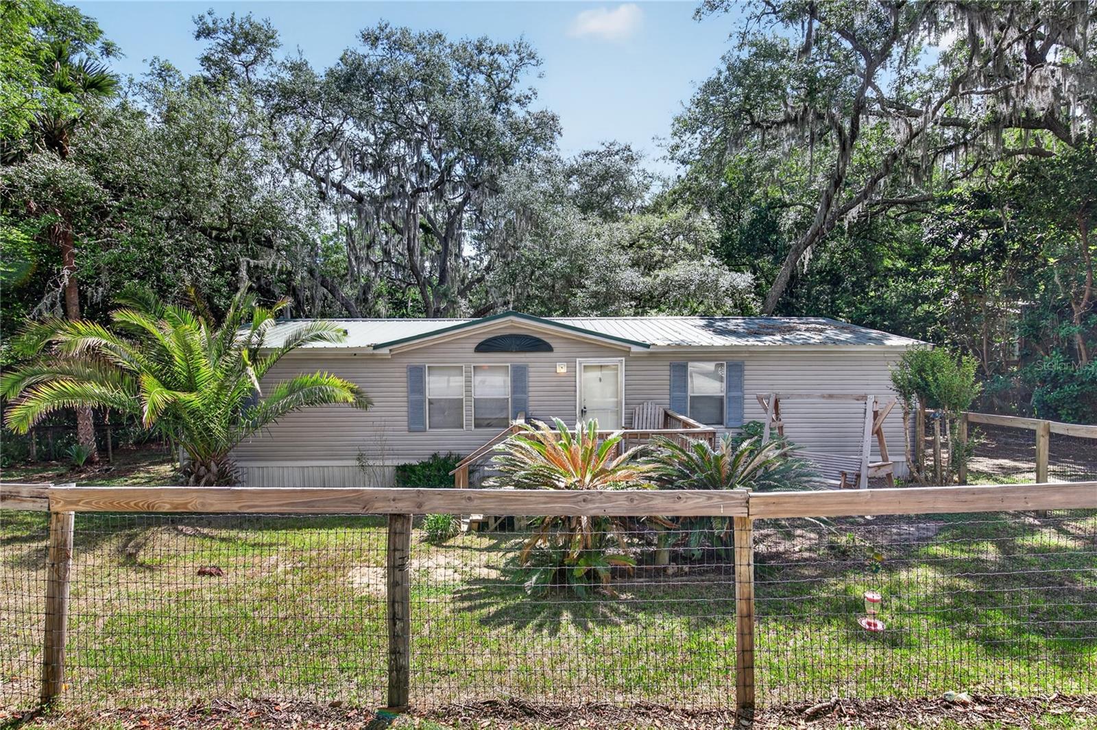 This home is 1350 sf , 3 bedrooms and 2 bathrooms. Relax on the back deck after a full day or watch the world wake up !  Travel .06 miles on the paved road  off the highway and enjoy living out in the country and away from the noise. Located not far from the Ocala National Forest. The shaded lot is cool..  HUNTER ??  Dog pens and deer cleaning area. Let's get that freezer full. A little TLC and you will have a nice place to call home. Even has a Dollar General about a mile away. No HOA to boot !