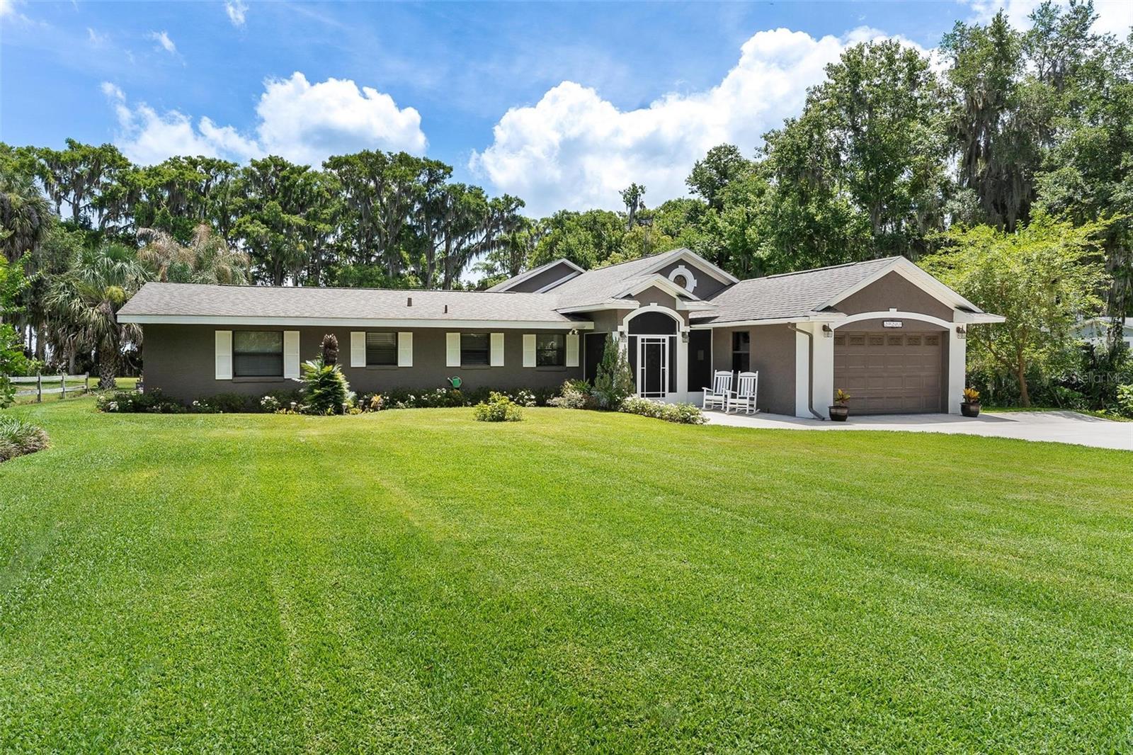 Beautiful lakefront home offering stunning water views with the added bonus of canal frontage along the side of the property. The private dock features water and electric, along with a boat lift equipped with a 2 horsepower motor, 50 amp service, and new wiring and motor. The 24x12 lift portion of the dock allows room to walk around comfortably, plus there is a separate 16x12 sitting area perfect for relaxing and enjoying the waterfront setting. A spacious 37x19 workshop provides ample room for storage, projects, or hobbies and includes a garage area, along with a 19x6 porch and an additional 7x17 covered area for even more functional space. The home also features a 10x8 front porch, plantation shutters throughout, and a 14x21 garage complete with a sink and counter space. Inside, the kitchen offers abundant cabinet space with built-in pantry storage, #3 granite countertops, and a breakfast bar that opens to the living room creating an ideal layout for entertaining. The living room features French doors leading to the massive screened room with large windows overlooking the lake, while the dining room also has French doors providing additional access to the screened area. The laundry room includes a sink and plenty of closet storage space for added convenience. The primary suite includes two walk-in closets and a beautifully remodeled walk-in shower in the primary bath. The second bathroom features a tub/shower combination. Enjoy waterfront living with plenty of indoor and outdoor space designed to take full advantage of the scenic lake and canal views.
