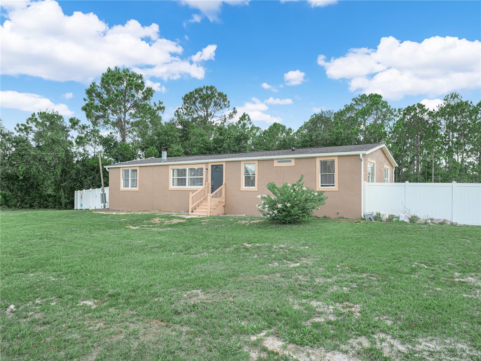 Welcome Home to 3559 Reagan Blvd!  Escape the hustle and bustle on this beautiful, unrestricted 1-acre parcel featuring a spacious and well-maintained 3 bedroom, 2.5 bathroom double wide manufactured home, this property perfectly balances peaceful country privacy with comfortable, modern living.  The thoughtfully designed open floor plan features a welcoming living area and 9-foot ceilings that make the space feel bright and airy.  Enjoy preparing meals in your large kitchen, complete with a generous eat-in island, soft close drawers and cabinets, and beautiful granite counter tops. The living room has a heat producing electric fireplace, the perfect place to cuddle up on a cold winter's night. Relax in the secluded family room, or retreat to the spacious owners suite, with his and hers walk-in closets and a huge ensuite bathroom with granite counter tops.  Step outside onto your back deck in the completely privacy fenced back yard.  With no HOA fees or restrictive rules, you can have animals or add a workshop.  The roof is only four years old, giving you peace of mind for years to come, and the solar panels bring your electric bill down to only $50 a month, just assume the cost for the panels. Located just minutes from Lake Wales, you get to enjoy quiet country living without sacrificing access to local schools, grocery stores and dining. With so much to offer, this home won't last long so schedule your showing today!