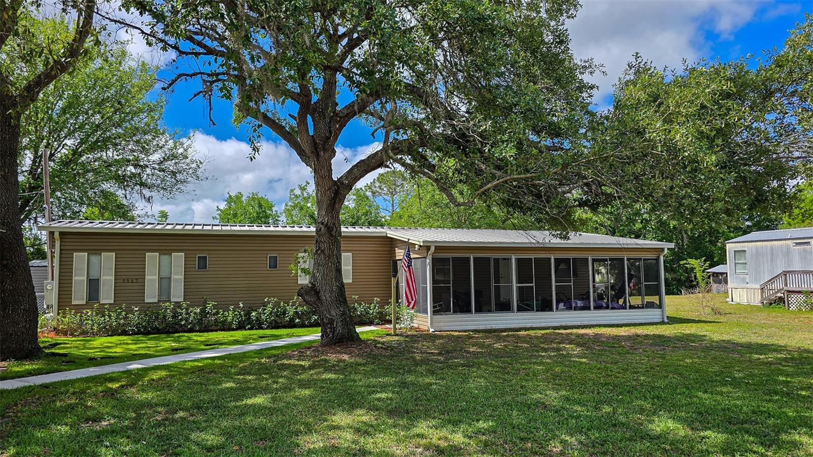 Honey, stop the car!! Check out this waterfront, furnished mobile home on a canal that leads right out to the lake!! Fishermen's dream home!! Nice, oversized screened room on the front. Lots of recent upgrades, including the kitchen cabinets, countertops and stainless appliances. Both bathrooms have been updated all the way around!! The inside has fresh paint, window blinds, vinyl flooring, baseboards, moldings, interior doors, electrical outlets and more!! The outside has a new HVAC system (2024), chain link fencing, new deck, new well pump and water filter system, upgraded plumbing (pvc) and a new storage building. The driveway has been paved and a carport added. It is move in ready!! Bring your suitcase and make yourself at home!! All new insulation and vapor barrier underneath scheduled for installation on June 9th.