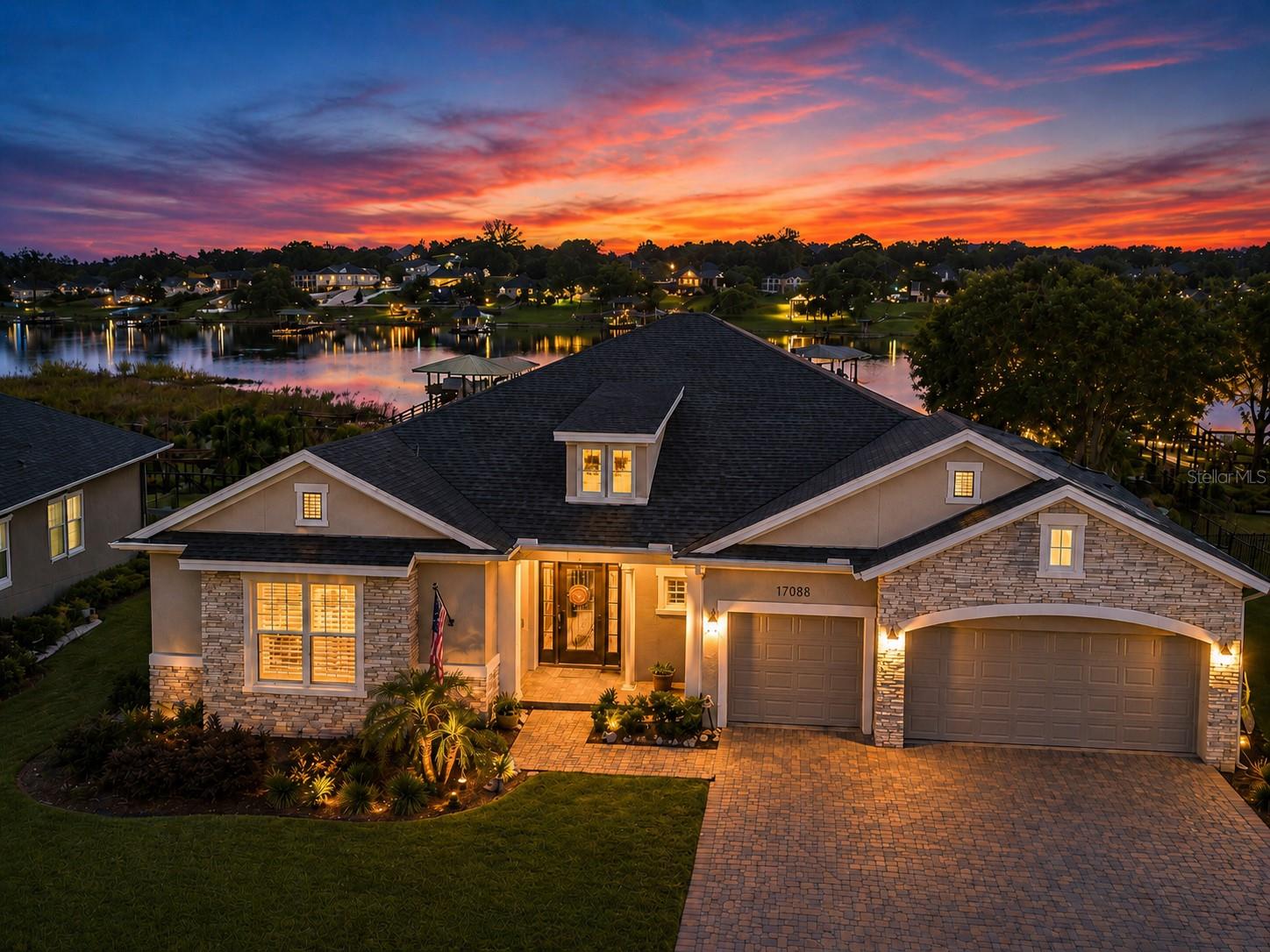 Welcome to 17088 Secret Hollow Loop, an upgraded lakefront David Weekley home in John’s Lake Landing, positioned directly on beautiful John’s Lake. Enjoy a 2,400-acre boat and ski lake, rated one of the top bass fishing lakes in Florida, lakefront living at its best. This sought-after Boulevard floor plan offers refined finishes, open living spaces, and an exceptional indoor-outdoor lifestyle. Interior features include 10-foot ceilings, 8-foot doors, crown molding, upgraded baseboards, custom window treatments, plantation shutters, and Mohawk laminate wood flooring throughout the main living areas. The kitchen features Cambria/quartz countertops, Timberlake full-overlay cabinetry, GE Café and GE Profile appliances, pendant lighting, and a buffet nook built-out beverage bar with kegerator and dual-drawer refrigerator/freezer. The family room opens through triple sliding glass doors to an expansive covered screen room with travertine flooring, outdoor kitchen, BBQ island, pool bath, ceiling fans, speakers, and TV mount. The owner’s suite includes a 12-foot ceiling, super shower and royal bath. Enjoy lakefront living with a lighted 160-foot dock leading to a 12x24 boathouse with boat lift, wave runner lift, seating, storage, ceiling fan, water bibs, and extra power receptacles. Additional features include a 3-car garage with epoxy floors, attic storage, overhead racks, security system, fiber optic service, HVAC air quality upgrade special filter and added UV light, and 300-amp electrical service for a future pool. John’s Lake Landing offers community amenities including a pool, cabana, and playground, with convenient access to Clermont, Winter Garden, major roadways, shopping, dining, recreation, and Central Florida attractions.