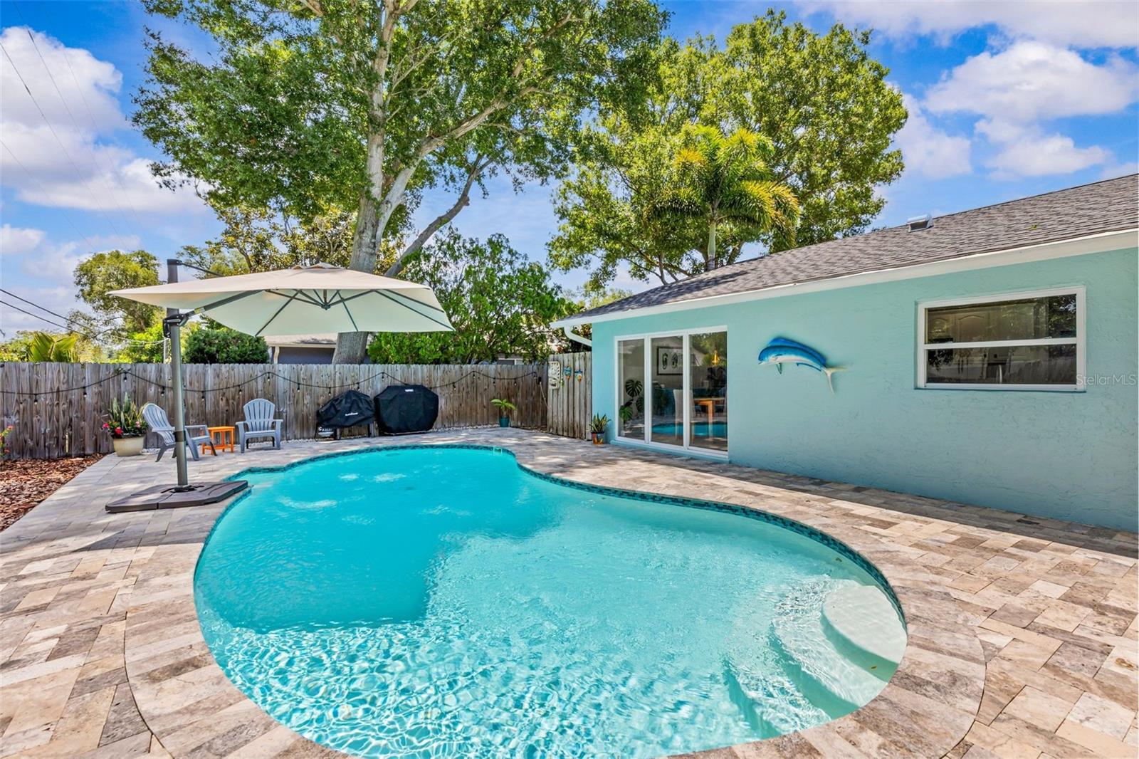 Coastal living, thoughtfully refined. Nestled within the family-friendly community of Seminole Grove Estates, this rarely available and completely reimagined residence presents an exceptional opportunity to enjoy the very best of Florida living. Resting confidently on a prominent corner lot at 68’ elevation, this solid block home is framed by lush tropical landscaping, mature oak trees and natural surroundings, offering timeless appeal and invaluable permanence. Cross the threshold and prepare to be embraced by a living experience designed to inspire and restore. The entryway sets the tone with sweeping views of the resort-style backyard and sparkling saltwater pool. Oversized windows bathe the interior with natural light, enhancing the home’s clean architectural lines, while the open-concept living and dining areas effortlessly balance connection and privacy. The heart of the home unfolds through an expansive kitchen featuring pristine granite countertops, curated finishes, and a statement peninsula with well-appointed seating, complemented by a rich palette of custom cabinetry, tailored storage solutions, and newer Samsung appliances (2024). The formal dining area and sophisticated beverage dry bar further elevate the experience, while elegant sliders extend the living space outwards to the covered travertine patio – perfect for alfresco dining, entertaining and intimate gatherings. The primary suite serves as a peaceful retreat with custom bamboo flooring, a walk-in closet, spa-inspired bath, and direct patio access overlooking the tranquil outdoor setting. Imagine enjoying your morning coffee by the pool as native wildlife quietly drift through the landscape. Three additional bedrooms continue the home’s inviting and understated aesthetic, while offering flexibility for guests, a private office, wellness space, or creative studio. Beyond its beauty, this residence has been meticulously maintained to provide comfort, durability and enduring value. Notable improvements include a new roof (2025), HVAC (2020), water heater (2025), updated windows and doors, fresh interior (2024) and exterior (2020) paint, updated gutters and soffits (2020), modernized pool equipment (2020), smart home automation, public water and sewer, and a generator inlet receptacle for added peace of mind. Ideally located, this community is just a short drive to TPA/PIE, and provides access to a wealth of amenities, including award-winning beaches, boating, championship golf courses, equestrian centers, recreational parks (Walsingham Park, Boca Ciega Millennium, Lake Seminole & Florida Botanical Gardens), free membership to Seminole Rec Center, dining, shopping, and world-class medical facilities. Just moments from the Pinellas Trail, enjoy miles of scenic walking and cycling paths connecting to charming downtowns, waterfront parks, coastal communities, and some of Pinellas County’s most beloved destinations. Non-deed restricted, no HOA/CDD, and A+ rated schools. Low-maintenance lifestyle to enjoy as a full-time residence, vacation home or investment opportunity.  Above flood plain and not within an evacuation zone; no flood insurance required. A detailed Feature Sheet is available upon request.