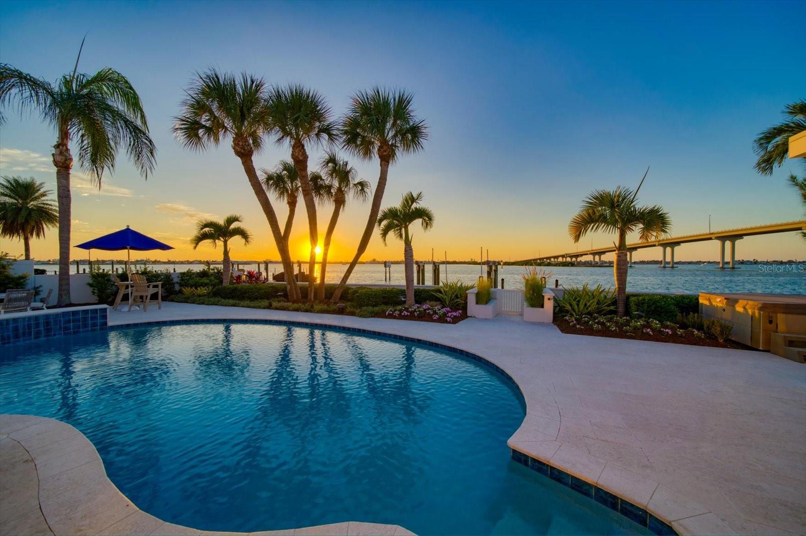Tucked away at the end of a quiet cul-de-sac in prestigious Harbor Bluffs, this move-in ready coastal masterpiece perfectly blends luxury, comfort, and Florida charm. From its West Indies–inspired entryway and pavered driveway framed by lush professional landscaping, to the metal roof and undeniable curb appeal, every detail exudes quality. Step inside and prepare to be captivated by endless water views that command attention from nearly every room. The wide-plank hardwood floors and soothing neutral palette create a tranquil backdrop for the open-concept design, ideal for both relaxed living and elegant entertaining. The kitchen is a showpiece with top-of-the-line Wolf and Sub-Zero appliances, a massive island with seating, custom walk-in pantry, a pot-filler and sparkling water views right from the sink. The dining and family rooms flow seamlessly, where walls of sliders invite the outdoors in, framing the intracoastal, pool, and Belleair Causeway beyond. The primary suite on the main level is a private retreat—wake up to breathtaking views, step through sliders to the pool, and enjoy a custom walk-in closet with an island and designer lighting. The spa-inspired ensuite offers dual vanities, a stunning walk-in shower, and a private water closet. Upstairs, a loft area makes an ideal office or creative space, while two additional bedrooms and beautifully appointed baths offer comfort and privacy. The outdoor living rivals any resort—featuring a sparkling pool, hot tub, pergola with TV and fireplace, and a vinyl dock with 30,000 lb boat lift for days spent on the water. Additional upgrades include impact windows and doors(including garage doors), tankless water heater, security and sprinkler systems, whole house generator, new electrical panel and more! Nothing has been left untouched. Perfectly located near boutique shopping, fine dining, and just a mile from the Gulf’s best beaches, this is more than a home—it’s a lifestyle defined by stunning views, quality craftsmanship, and effortless elegance.