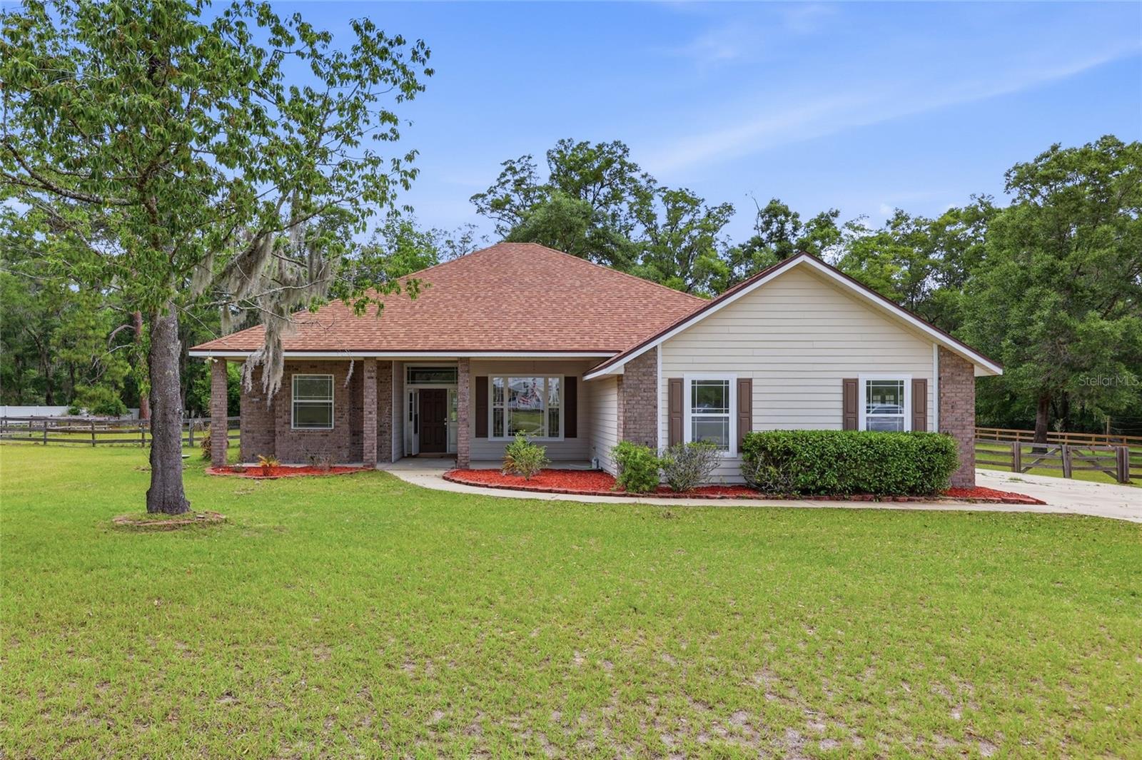 One or more photos were virtually staged (fire shown in fireplace). Why settle for ordinary when you can own a 1.29-acre fenced property featuring a stately 2,926 sq ft home that backs up to a wooded parcel for ultimate privacy! This 4-bed, 3-bath home sits back on a vast front lawn with a side-entry garage, creating an impressive and welcoming presence. Opening the front door reveals a dramatic interior showcasing soaring ceilings, enduring tile flooring, and graceful archways that frame the entrances to each section of the home’s 3-way split floor plan. Just off the foyer, oversized glass French doors lead into a huge Florida room with tile flooring and beautiful views of the backyard. This home’s elegant transitions also lead to a formal dining room and into the heart of the home, where a spacious living room is complemented by a gas fireplace flanked by custom built-ins, a striking arched transom window, and additional French doors leading to the Florida room. This central hub connects effortlessly to a gourmet kitchen outfitted with crisp white cabinetry, decorative brick-style backsplash, a central granite prep island, and a large walk-in pantry, with an inviting breakfast nook perfectly positioned for casual meals. The primary suite is separate from the guest bedrooms for added seclusion and features rich wood laminate flooring, dual walk-in closets (including one with a large safe), and a lavish ensuite complete with a Jacuzzi tub, separate walk-in shower with dual showerheads, double vanities, and a private bidet. The guest bedrooms offer luxurious carpeted comfort, including one with its own private ensuite bathroom. Both guest bathrooms are strategically placed, with one providing direct access to the rear of the home. A functional laundry and mudroom with a utility sink and washer/dryer hookups provides a convenient transition to the oversized two-car garage, while the grounds include a sturdy storage shed and a concrete slab patio. Situated in River Run Plantation, this property is less than a half-mile from the community river park and boat ramp. It is also located just 3 miles from the historic shops and cafes of downtown High Springs and within 6 miles of the world-famous Ginnie Springs, all while maintaining an easy 25-mile commute to the heart of Gainesville. This exceptional property is ready for its next chapter; reach out to schedule your private showing today!