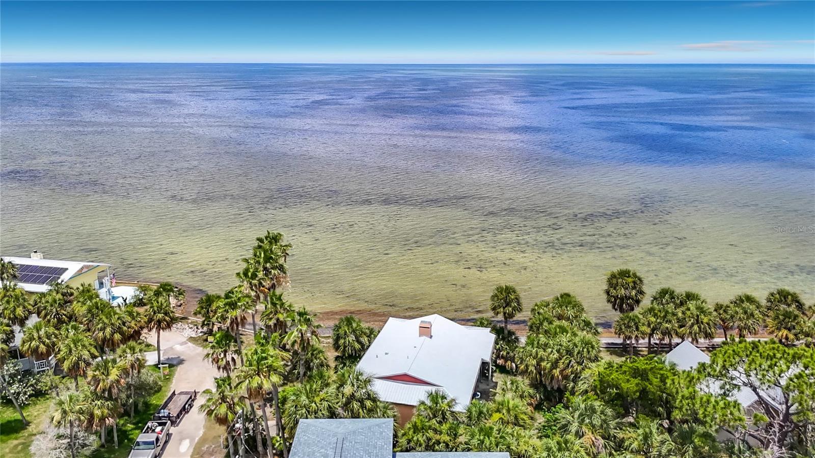 Wake up to breathtaking Gulf views and experience the laid-back charm of island living on Pine Island! Opportunities like this are incredibly rare. With panoramic Gulf views, an unbeatable waterfront location, and timeless architectural character, this elevated coastal retreat is ready for its next chapter. While the interior offers the chance for your own personal updates and design vision, the home's setting, spacious layout, and endless outdoor living spaces create the perfect canvas for your dream Florida getaway.

Designed to embrace its incredible surroundings, the home features an expansive wraparound porch and an extended balcony that provide the perfect place to enjoy morning coffee, spectacular sunsets, and endless water views. Tropical landscaping surrounds the property, creating an inviting island atmosphere before you even step inside.

The inviting interior blends warmth and character with coastal elegance. The open living room showcases striking wood-beam ceilings, a beautiful fireplace, and large windows that fill the space with natural light while framing the spectacular water views. The dining room flows effortlessly into the kitchen, making entertaining family and friends easy and enjoyable. Two comfortable bedrooms and two full bathrooms provide plenty of space for weekend getaways or year-round living. 

Built for both beauty and peace of mind, the home features a 2024 metal roof and an elevated design with covered parking below. The spacious ground level offers endless possibilities for additional storage, a workshop, or creating the ultimate outdoor living and entertaining space.

Adventure begins right outside your door. Launch your kayak, paddleboard, or small to mid-size boat from the nearby community boat launch just steps away, or spend the day exploring the crystal-clear waters of the nearby Weeki Wachee River. The famous Weeki Wachee River State Park is only minutes away, offering endless opportunities for boating, kayaking, paddleboarding, and unforgettable Florida adventures.

One of the most exciting features is the flexibility this property offers. With no rental restrictions, this home presents an exceptional opportunity as a private island retreat, full-time residence, or make into a vacation rental

Take a short stroll or golf cart ride to Alfred McKethan Pine Island Park, where you'll enjoy a Gulf-front beach, playground, volleyball courts, picnic areas, and a concession stand. Pine Island itself is one of Florida's hidden gems—a quaint island community measuring just six blocks long and two blocks wide with approximately 40 homes, creating an atmosphere that feels worlds away from the everyday.

For just $40 per year, the optional HOA provides access to a private community dock, boat ramp, and beach, making it even easier to enjoy everything island life has to offer.

Whether you're searching for a peaceful waterfront escape, a full-time island home, or an income-producing vacation rental, this exceptional property offers a rare combination of breathtaking Gulf views, incredible potential, and one of Florida's most sought-after coastal settings. Bring your vision, add your personal touches, and transform this island gem into the waterfront retreat you've always imagined.

Schedule your private showing today and experience the magic of Pine Island—where unforgettable sunsets, endless adventures, and the Florida lifestyle you've been dreaming of await.