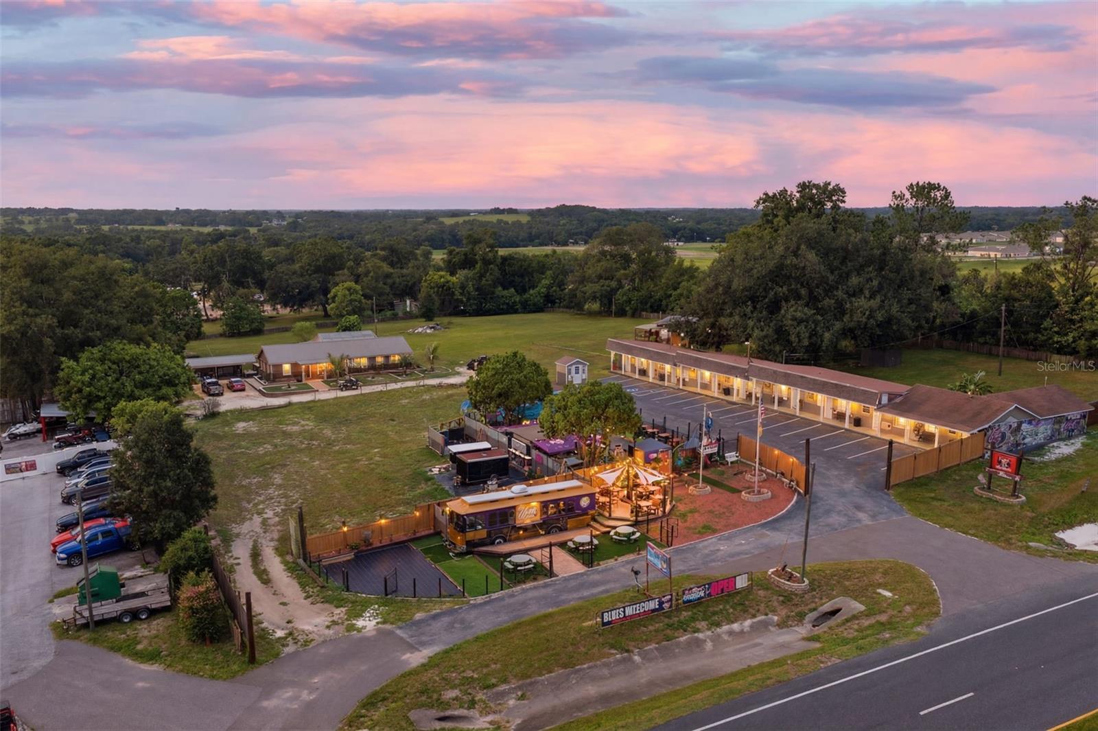 Rare opportunity to acquire a highly versatile, fully renovated, commercial hospitality property situated on approximately 3.81 acres along Gall Boulevard/US 301 in Zephyrhills. Offered at $3,750,000, this is more than an investment property—it is a true lifestyle purchase and exceptional owner-operator opportunity.
The property includes an operating nine-unit motel, a fully renovated three-bedroom, two-bath single-family residence with a private pool, and an approximately 1,500-square-foot detached garage/workshop. The on-site residence allows an owner to live comfortably at the property while directly operating and overseeing the hotel, motel, restaurant, bar and entertainment components.
The motel offers flexibility for nightly, weekly, extended-stay or potential long-term rental use, subject to applicable licensing and regulations. The property also features an outdoor food-and-beverage and entertainment area currently operated through a food truck and outdoor bar, creating an opportunity for restaurant service, private events, live entertainment and additional hospitality uses.
Further expansion potential includes plans for 10 RV or glamping pads, along with plans that have been created for the county for two additional buildings containing up to 45 additional hotel rooms. These proposed improvements create substantial long-term growth potential for an experienced hospitality operator, developer or investor. All future development remains subject to final zoning, permitting and governmental approvals.
The parcel is zoned C-2 General Commercial, carries a hotel/motel land-use classification, is located within a designated Opportunity Zone and is identified in Flood Zone X. With prominent frontage along a major Zephyrhills commercial corridor, multiple existing uses, an on-site residence and significant development potential, this property offers a rare opportunity to live, work and operate several complementary businesses from one location.
Detailed income, operating records and development information are available upon request with appropriate confidentiality. All property information, permitted uses, licenses, submitted plans and financial data should be independently verified by prospective purchasers.