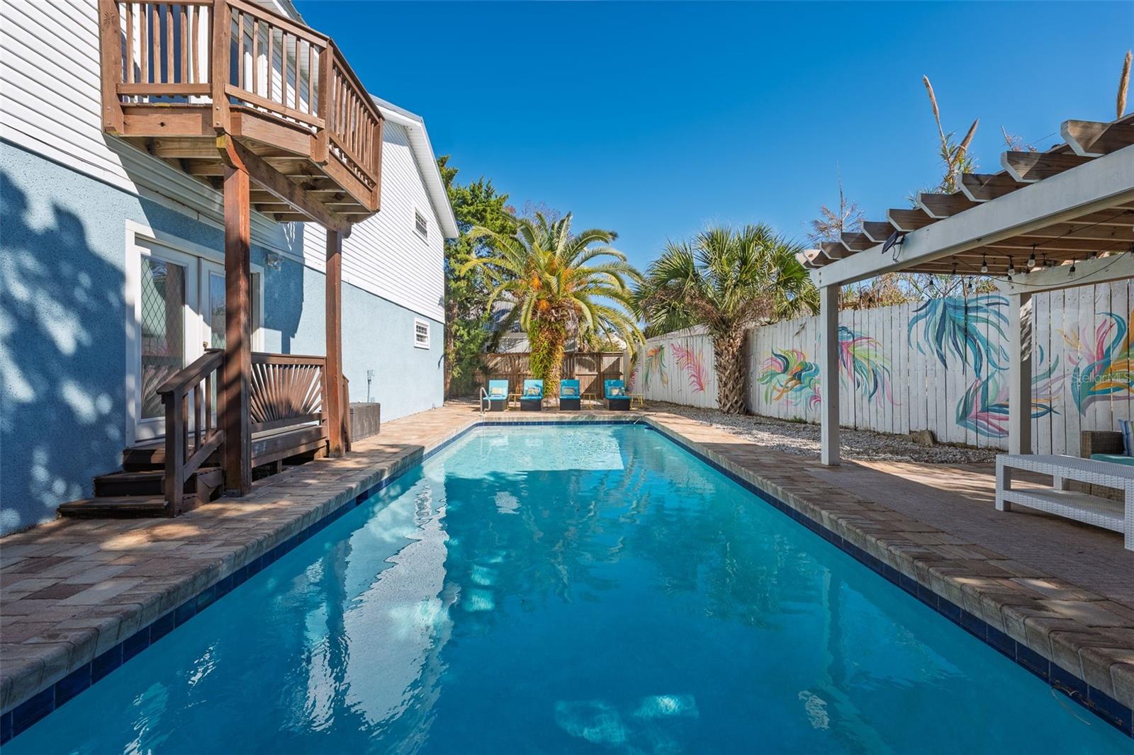 Short-term rentals allowed with no minimum restrictions—an incredibly rare opportunity to own a fully furnished, turnkey POOL home just a short walk to the beach, as well as local coffee shops, restaurants, and boutique shopping on Anastasia Island.
Thoughtfully designed for both guest experience and functionality, this two-story home offers a flexible layout ideal for personal use, vacation rental income, or a combination of both. The main living level features an open-concept great room with vaulted ceilings, creating a bright, airy space that flows seamlessly into the kitchen and dining area. Just off the kitchen, a screened-in sunroom provides the perfect setting for outdoor dining, allowing you to enjoy coastal breezes year-round in comfort. A convenient half bath is also located on this level.

The primary suite is also located on the main living floor, offering privacy and easy accessibility. From the living room, step out onto a deck overlooking the pool—perfect for morning coffee or evening relaxation.
On the ground level, you’ll find two additional bedrooms, a full bathroom, and access to the two-car garage, which has been thoughtfully converted into a custom game room. This added entertainment space is a standout feature for guests and significantly enhances the property’s short-term rental appeal.
The outdoor living area is a true highlight, designed for both relaxation and entertaining. The fully fenced backyard features a heated in-ground pool, covered pavilion, paver patio, and multiple gathering spaces—creating a private coastal retreat just minutes from the beach.
Recent upgrades add both value and peace of mind, including pool resurfacing and retiling (2025), pool automation with app control (2025), new dishwasher and range (2025), new backyard fencing (2025), screened front porch (2024), garage flooring (2023), dryer (2023), and water heater (2023).
Offered fully furnished and turnkey, this property is ready for immediate use or income production.