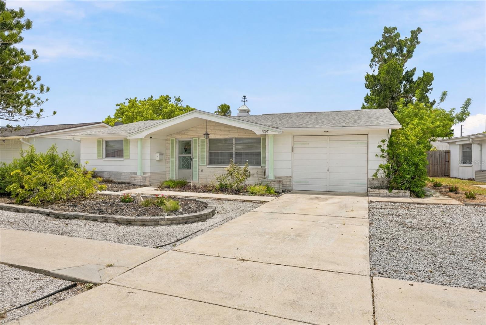 The Home was owned and occupied, and well maintained exclusively by one family; never any tenants. The roof was replaced about three years ago. Living, dining, and kitchen have terrazzo flooring; bedrooms and baths are carpeted over terrazzo. All walls and ceilings are plastered white. All plumbing is in good condition and has been repaired or replaced as necessary. All existing blinds and curtains are included with sale.
The cozy Florida Room at the rear of the house has a private exit door to the rear patio. This room could be converted to a bedroom if a partition & door were installed.  
 
The Front Yard is covered with white shells in some areas, and brown pine bark in other areas. There is no grass to mow. The yard has an elevated central mound surrounded by paving wedges and containing a gardenia plant, a holly tree, and an 80 ft tall Norfolk Island Pine. Two palms grow next to the road. A stone-covered area next to the driveway is available for supplemental parking, as no parking is allowed on the street.
 
The Back Yard is enclosed by neighbors’ fencing.  Pine bark covers the yard, so there is no grass to mow here as well. It contains a large cedar tree plus a couple of blueberry plants and some aloe plants.  Plenty of room for planting a garden, trees, and other plants.
 
The Garage contains four shelving units and a workbench with vice. Up front is an 80 gallon electric hot water tank, washer, utility sink, and dryer. The hot water tank was connected to a roof-top solar collector (was damaged and removed during re-roofing),  but a collector could be reinstalled if desired, as the necessary connections are still there. Plywood sheets to cover windows during hurricane season are stored overhead. An irrigation pump is located next to the north wall, is not used because well went dry.
 
Electrical Panel has been fully updated to comply with all current Pasco County zoning requirements.
 
Heating and Cooling is provided by a central HVAC unit located in the attic above the garage. Additional Heating could be supplied by electric baseboard units in most rooms.