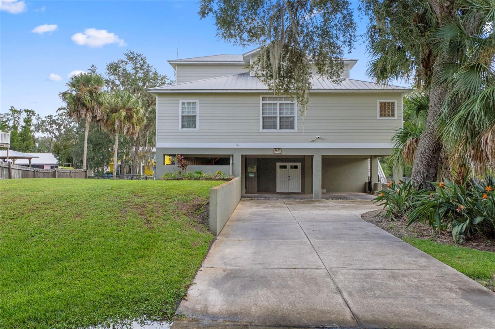 Experience Gulf Coast lifestyle in this elevated custom waterfront home offering deep water, direct Gulf access—perfect for boating enthusiasts and nature lovers alike. With 4 spacious bedrooms and 3 full baths, this home is designed for both comfort and flexibility. The three-story layout includes covered parking for 2 vehicles and an expansive lower-level area with a tackle room complete with ice machine hookups and extra storage, plus a huge space ideal for a workshop, hobby area, or even conversion into additional indoor/outdoor space. A sturdy dumbwaiter makes it easy to transport groceries or gear upstairs. On the main floor, you’ll find a welcoming living space with custom built-ins and an inviting screened porch overlooking the water—perfect for relaxing and entertaining. The primary suite features an electric fireplace and large ensuite. All bedrooms are generously sized, offering plenty of room for family and guests. The fenced backyard is a true Florida retreat, complete with mature fruit trees, a ground-level deck, firepit, and hammock area. Boaters will love the 75 feet of dock space with room for two large boats, a rip-rap concrete seawall, floating dock with water and 30-amp power, a fish-cleaning station, and easy access to a nearby boat ramp. Currently operating as a successful short-term rental, this home also offers the opportunity to continue as an income-producing property—all contents are negotiable for a turnkey setup. Best of all, there are no deed restrictions, giving you the freedom to use it however you choose.