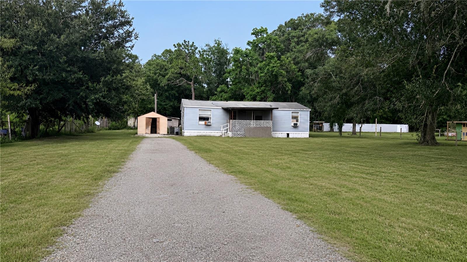 INVESTOR / HANDYMAN SPECIAL • MASSIVE POTENTIAL • INCREDIBLE .63 ACRE LAND OPPORTUNITY!
Positioned on a fully fenced and gated 0.63-acre parcel with AR (Agricultural SFR/MH) zoning, this property presents an exceptional opportunity for investors, builders, cash buyers, or anyone looking to create their own private homestead.

The existing 3-bedroom, 2-bath manufactured home is approximately 960 square feet, features a split-bedroom floor plan, and includes an attached rear porch. The structure requires substantial rehabilitation or removal, making this the perfect value-add project or future homesite.

HIGHLIGHTS:
No HOA & No CDD Restrictions: Enjoy the freedom to park RVs, boats, trailers, work vehicles, and recreational equipment without restrictive community regulations.
Flexible Zoning: Renovate the existing structure, replace it with a new manufactured home, or build your dream site-built residence (buyer to verify all intended uses).
Added Utility: The spacious lot is beautifully shaded by mature trees and includes two storage sheds—perfect for securing tools and equipment while you plan your next project.

LOCATION, LOCATION, LOCATION!
Tucked away in Angus Valley for ultimate rural privacy, you are just minutes from Old Pasco Road, I-75, schools, hospitals, and all the premier shopping and dining of Wesley Chapel.
Whether you're planning your next flip, adding to your rental portfolio, securing a future homesite, or investing in land within one of Pasco County’s fastest-growing corridors, opportunities like this are becoming increasingly rare at this price point. Bring your vision and unlock the endless long-term equity potential of 6408 Woodsman Drive!