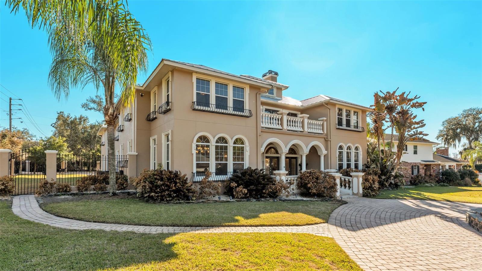 For those who appreciate space, privacy, and elevated living, this extraordinary Lakeland, Florida estate is now offered at a NEWLY IMPROVED PRICE, creating a rare opportunity to own one of the area’s most impressive private residences. This stunning luxury estate, perfectly set on a private half-acre with nearly 7,500 square feet of beautifully updated living space is designed for comfort, entertaining, and upscale Florida living. This expansive two-story home offers 6 bedrooms, 7 fully updated bathrooms, formal dining, private office, gym/flex space, game room, great room, separate apartment, and a private theater, delivering a true luxury lifestyle with room for everyone. Arrive through the grand circular paver driveway framed by stately columns and French doors, then step inside to travertine floors, soaring 10-foot ceilings, and a cozy wood-burning fireplace. The oversized reimagined primary suite features new porcelain tile, French doors to the pool and spa, a spa-style bath with granite countertops, expanded tiled shower, jacuzzi tub, and custom walk-in closet with plush new carpet. The updated chef’s kitchen shines with granite countertops, large center island, stainless appliances, and updated cooktop, flowing seamlessly into the theater room with upgraded entertainment system and elegant porcelain tile. Upstairs offers a second family room, four spacious bedrooms with walk-in closets, and French doors leading to a private balcony. A private 1-bedroom apartment with separate entrance includes a full kitchen with new granite, living room with updated solid wood flooring, and fully renovated bath—perfect for guests or multigenerational living. Outside, enjoy your resort-style backyard with covered lanai, resurfaced saltwater pool and spa, amazing gazebo style outdoor kitchen with charcoal smoker, propane flat-top, sink and granite counters, plus a pool bath and personal sauna. Additional highlights include gated private rear entrance leading to the garage, custom metal fencing with stone pillars, extended paver parking ideal for RV or boat storage, brand-new metal roof (2024), refreshed exterior paint (2024), updated landscaping, A/C systems, water heaters, security cameras, and more. Located in an exclusive South Lakeland neighborhood with NO HOA, this exceptional property blends privacy, convenience, and high-end upgrades throughout—schedule your private tour today and experience luxury living in Lakeland, Florida at its finest.