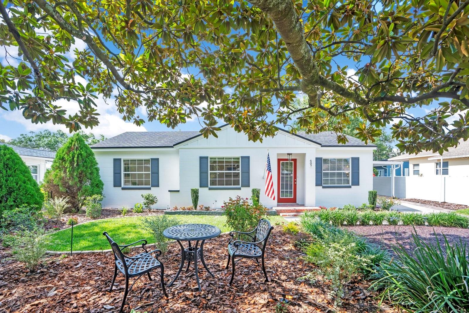 Thoroughly reimagined for contemporary luxury, this meticulously curated 4 bedroom, 2 bathroom cottage offers an exceptional residential experience in the heart of Central Lakeland. Nestled within the highly coveted Kerneywood neighborhood, this location serves as the ultimate gateway to all things Lakeland. Residents will enjoy a prime location blocks away from top rated schools, Florida Southern College, the Common Ground playground, bike paths, and tennis courts, alongside effortless proximity to Lake Hollingsworth, downtown dining, Publix, and the Polk Parkway.
Every square foot of this thoughtful renovation speaks to the discerning homeowner, offering complete peace of mind with a recently replaced roof, updated HVAC systems, a modern primary addition as well as a full home security system. The exterior has been exceptionally upgraded this year with new paint and durable Hardie board siding along the gables, soffit, and fascia. Inside, the exquisite split floor plan features a streamlined galley kitchen complete with a dedicated pantry, feeding directly into comfortable living spaces drenched in natural light. The primary suite serves as a true sanctuary, boasting a versatile flex space ideal for an in home office, a private sitting area, or a nursery, completed by a dedicated inside laundry suite positioned perfectly off the main bedroom. Practical infrastructural upgrades include natural gas integration and a dedicated exterior generator plug in.
Outside, the grounds are an absolute gardener’s paradise, framed by mature landscaping and punctuated by an expansive pavered backyard lounge designed for quiet morning coffee or weekend entertaining. Everyday convenience is further realized through ample guest parking and a pristine carport. Capping off this masterfully designed property is an abundance of organization options, featuring incredible interior storage solutions and multiple detached exterior storage structures. Combining classic character with uncompromising modernity, this Kerneywood home is a rare find.