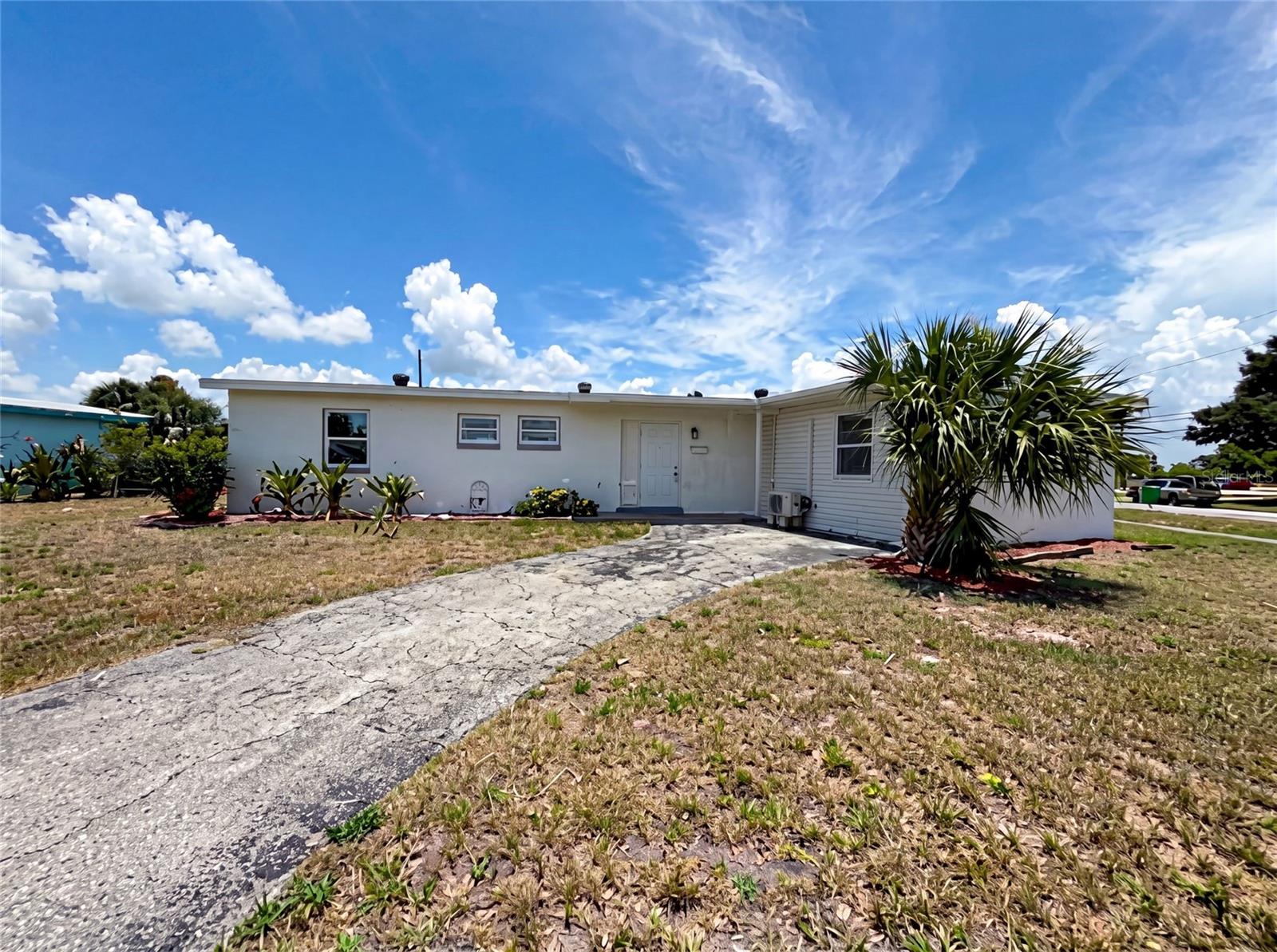 Virtually Staged. 21530 Glendale Ave is a single-story Port Charlotte single-family home built in 1961, offering 3 bedrooms and 2 full bathrooms across 1,888 square feet on a 10,904-square-foot lot. The kitchen features white cabinetry, white quartz countertops, a tile backsplash, stainless steel appliances, and an island with a sink that opens to the living and dining area. The main living space includes a brick fireplace and large sliding glass doors that provide backyard access and natural light. All three bedrooms have hardwood-style flooring. Both bathrooms include tile surrounds and tub-and-shower combinations. A concrete pad in the backyard provides outdoor space. The open floor plan and updated interior finishes complete this well-maintained residence.. Included 100-Day Home Warranty with buyer activation