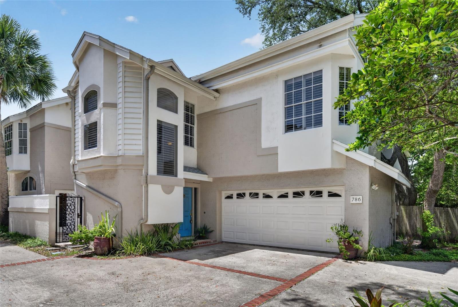 Virtually Staged. Welcome to 786 McIntyre Avenue, Winter Park, FL 32789—a serene retreat perched on a picturesque tree-lined brick street in one of Winter Park's most desirable neighborhoods. Just a short stroll from Rollins College and the renowned shops, restaurants, and charm of Park Avenue, this exceptional single-family townhome offers the perfect blend of comfort, style, and location—with no HOA!

A charming driveway leads to the attached two-car garage and private front entrance. Inside, you'll be welcomed by a bright, airy interior featuring soaring ceilings, dramatic high windows, abundant natural light, and a cozy wood-burning fireplace. The spacious living room is surrounded by two private patios, creating a seamless connection between indoor and outdoor living.

The updated kitchen boasts modern cabinetry, an open breakfast bar, and a cheerful eat-in dining area with direct access to one of the patios. The formal dining room, currently used as a home office, opens to the second patio, making it the perfect setting for al fresco dining or entertaining.

Upstairs, the impressive 23' x 12' primary suite offers a peaceful retreat, complete with a spacious 20' x 8' ensuite bathroom. Two additional guest bedrooms share a convenient Jack-and-Jill bathroom, providing comfort and privacy for family or visitors.

Meticulously maintained, this home features numerous recent updates, including a new HVAC system (2025) and beautiful wood shutters throughout.

Located in the highly sought-after Audubon K-8 and Winter Park High School districts, this exceptional home combines timeless character, modern updates, and an unbeatable location.  WELCOME HOME!