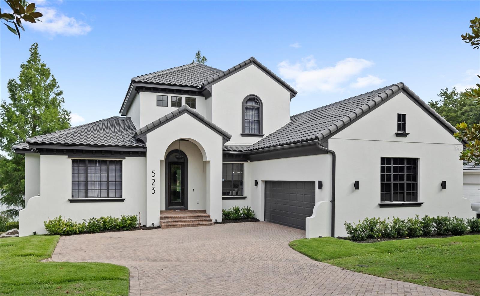 One or more photo(s) has been virtually staged. New tile roof! Welcome to a fully updated 4,000 sq ft lakefront retreat in the gated community of Blue Lake Estates. Positioned at the end of a quiet cul-de-sac on the shores of Blue Lake, this custom-built Mediterranean estate offers three levels of updated and modern living space. Inside, soaring ceilings, abundant natural light, and panoramic lake views are the first impression. The updated gourmet kitchen anchors the main level of the home, and features granite countertops, stainless steel appliances, double ovens, a wine refrigerator, coffee bar, breakfast nook, and plenty of cabinetry. The kitchen overlooks the great room, which features a custom fireplace. Adjacent to the kitchen is the butler’s pantry and formal dining room.
The first-floor primary suite offers lake views and an en-suite featuring dual vanities, a soaking tub, and a walk-in shower. The main level of the home also includes a dedicated home office with French doors. Upstairs, you'll find a large loft and two spacious guest suites, each with their own en-suite. The unique lower level offers incredible flexibility with two additional bedrooms, a full bath, a large bonus/family room, storage, and a second screened patio. The home has been finished with new flooring throughout, as well as other modern details like the new stair railing. Outside you are welcomed to your private lakefront. Enjoy fishing, kayaking, paddleboarding, and the scenery of the pristine 17-acre Blue Lake. The outside is complete with a fully fenced backyard, expansive outdoor living spaces, and mature landscaping. Brand new tile roof replaced in 2025, HVAC replaced in 2025 and water heater replaced in 2024! The nearby parks and recreational areas provide opportunities for outdoor activities. Situated only minutes to downtown Mount Dora and downtown Eustis, and 15 minutes to SR 429 route to Orlando. This offers easy access for commuting or enjoying amenities in the City of Orlando, at Disney and the airport. Call today to schedule a private tour.