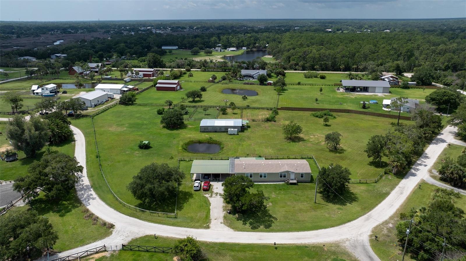Peaceful country living with coastal convenience! This 4BR/2BA spacious home has 2,250 sq.ft LA + a large screened porch overlooking 3.63 beautiful acres, offering plenty of room to enjoy a peaceful lifestyle while being just minutes from the beach, shopping, dining & everyday conveniences. Bring the horses, chickens, goats, gardens or even a large boat or RV, this property can handle them all. Modular home built in 2010 features an open floorplan with crown molding, coffered ceilings, recessed lighting, screen porch, city water, large kitchen with gas range, island and walk-in pantry. Upgrades include new roof 2024, new fencing in 2024, new vinyl laminate flooring in all living areas & the MBR and new carpet in the other 3 BRs in 2024, & a new A/C 2019. A large propane tank provides gas for the stove & oven, water heater & dryer. The primary suite features a separate bonus room that could be used as an office, baby nursery, craft room or even a 5th bedroom. The primary bathroom has double vanities, walk-in shower, garden tub and super sized walk-in closet. The center-aisle barn has electricity & water, a metal roof, is 60’x30’ & has 8 stalls, a tack room & a feed room. Property is fenced and cross fenced with 2 paddocks behind the barn. An electric fence is buried around the perimeter of the house and part of the pasture & can be included with a dog collar. There is a carport with four spaces and a roof clearance of 9’2” for larger trucks, RVs or boats. The home did not flood in the hurricanes of 2022 although water did cover the pastures & barn. Only 3.5-miles to Canal Street, 6-miles to Flagler Avenue, 7-miles to the beach and 4-miles to I-95. This unique property is ready to become your own private paradise!